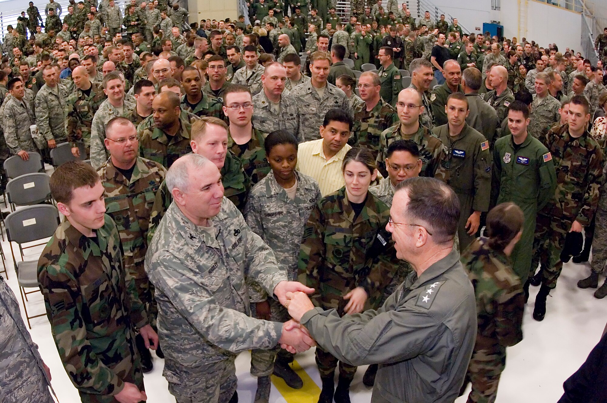 Navy Adm. Mike Mullen, chairman of the Joint Chiefs of Staff and the nation's top military officer, hands a coin to Col. Jon Huguley, 446th Maintenance Group commander, Thursday after a briefing in Hangar 9. During the briefing, Admiral Mullen thanked Airmen and family members for their contributions, outlined some changes and challenges the military will face in the future and discussed the importance of leadership. (U.S. Air Force photo/Abner Guzman)