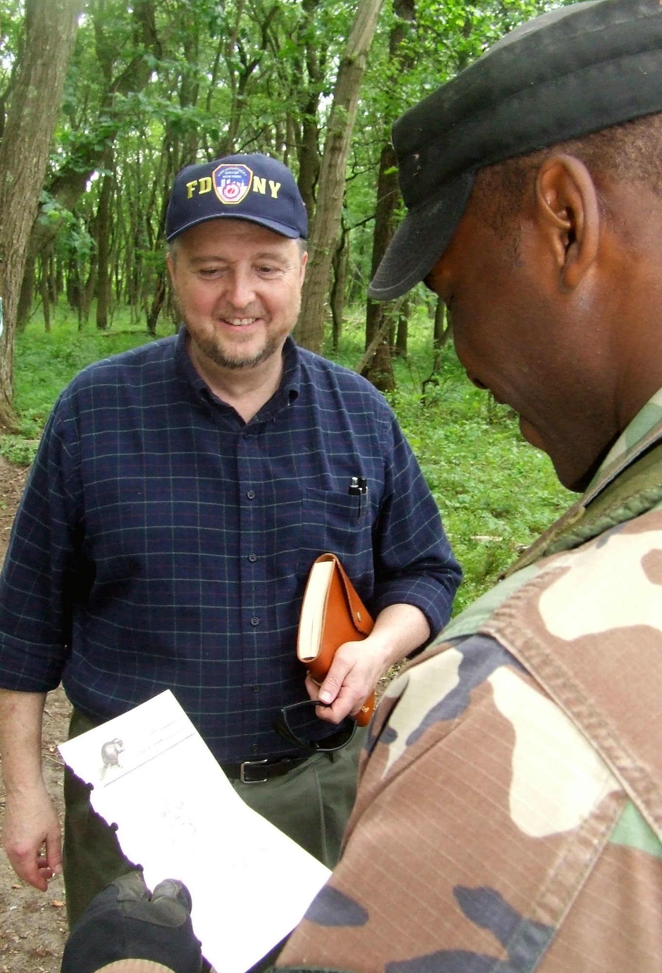 Tech. Sgt. Rudolph Stuart, an instructor with the U.S. Air Force Expeditionary Center's 421st Combat Training Squadron, looks over a sketch given to him by artist William Frake on a Fort Dix, N.J., range June 19, 2008.  Mr. Frake was one of five artists visiting the USAF EC and its training courses as part of an official visit with the Air Force Art Program.  (U.S. Air Force Photo/Tech. Sgt. Scott T. Sturkol)