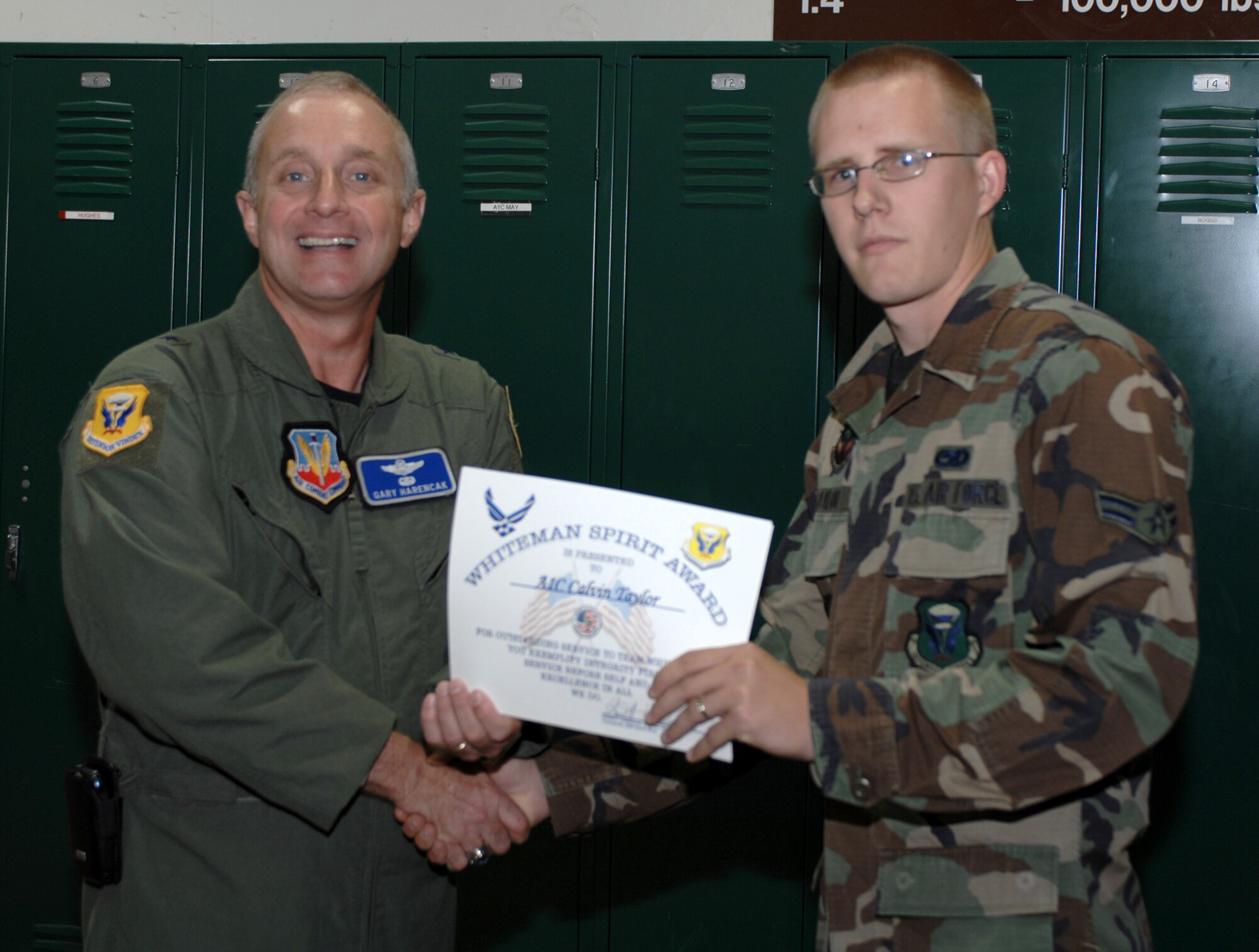 WHITEMAN AIR FORCE BASE, Mo., -- Brig. Gen. Garrett Harencak, 509th Bomb Wing commander, presents Airman 1st Class Calvin, 509th Munitions Squadron, with the Whiteman Spirit Award June 16.