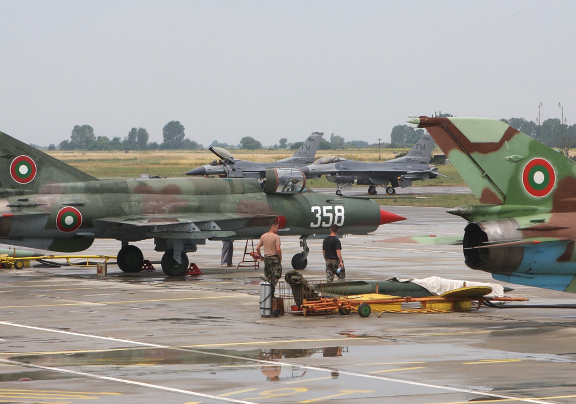 GRAF IGNATIEVO AIR BASE, BULGARIA - Two F-16s from Homestead Air Reserve Base (background) are parked along with Bulgarian Air Force MiG 21 fighter jets (foreground) at Graf-Isnatievo Air Base, Bulgaria. Approximately 200 Airmen and 10 F-16s from Homestead Air Reserve Base deployed to train with the Bulgarian Air Force. While deployed, the Airmen raised $2,800 to purchase the medical device for the children’s ward at a hospital in the nearby City of Plovdiv. This particular medical measuring device is of critical importance in emergency medicine and is very useful for patients with respiratory or cardiac problems. (U.S. Air Force photo by Tech. Sgt. Bucky Parrish)