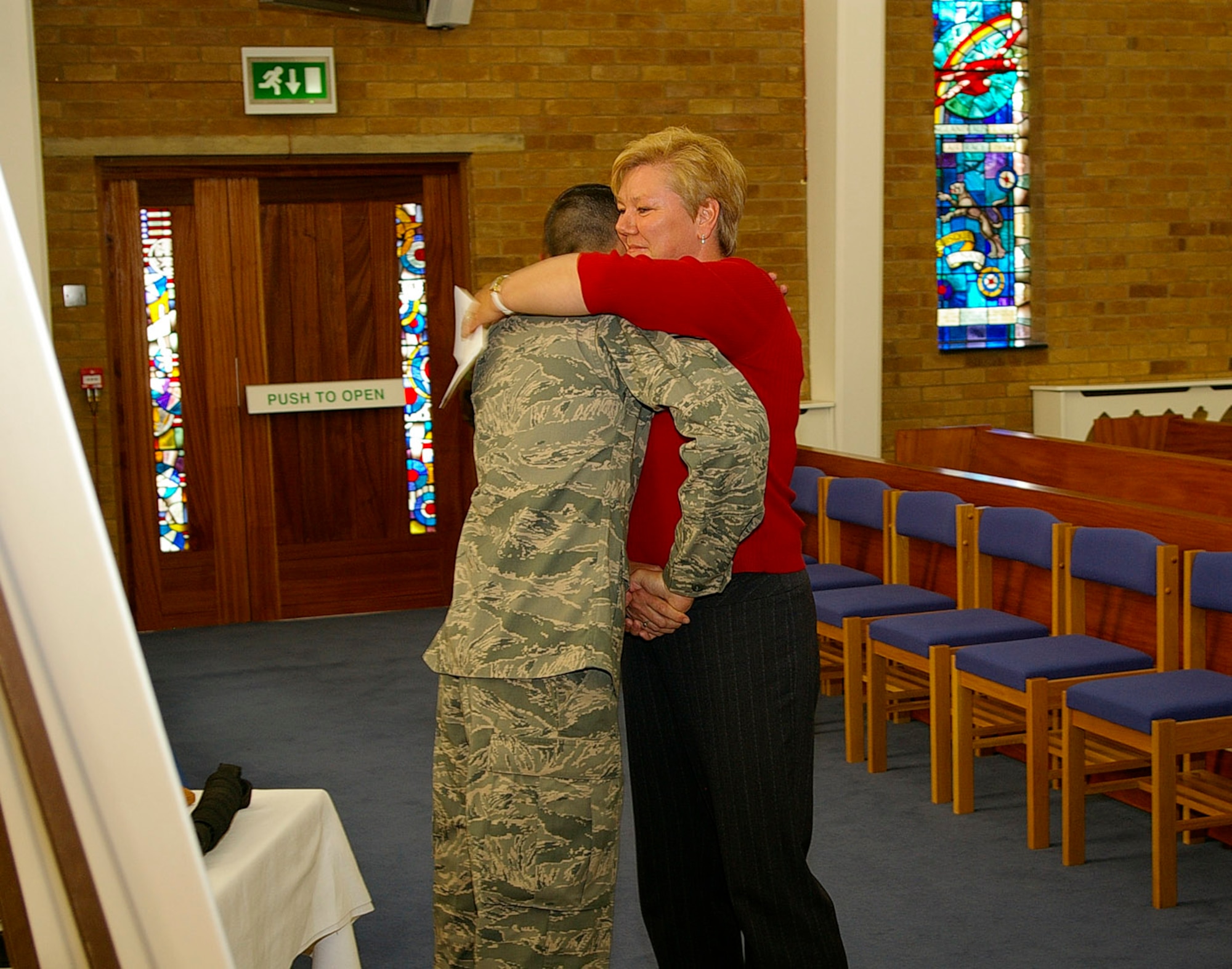 Sergeant Bradt, 100th SFS, left, shakes the hand of Debbie Black, 100th SFS kennel assistant, as she gives him a hug after the memorial service for Military Working Dog War. Ms. Black looked after War for more than six years, and Sergeant Bradt was his handler. (U.S. Air Force photo by Karen Abeyasekere)