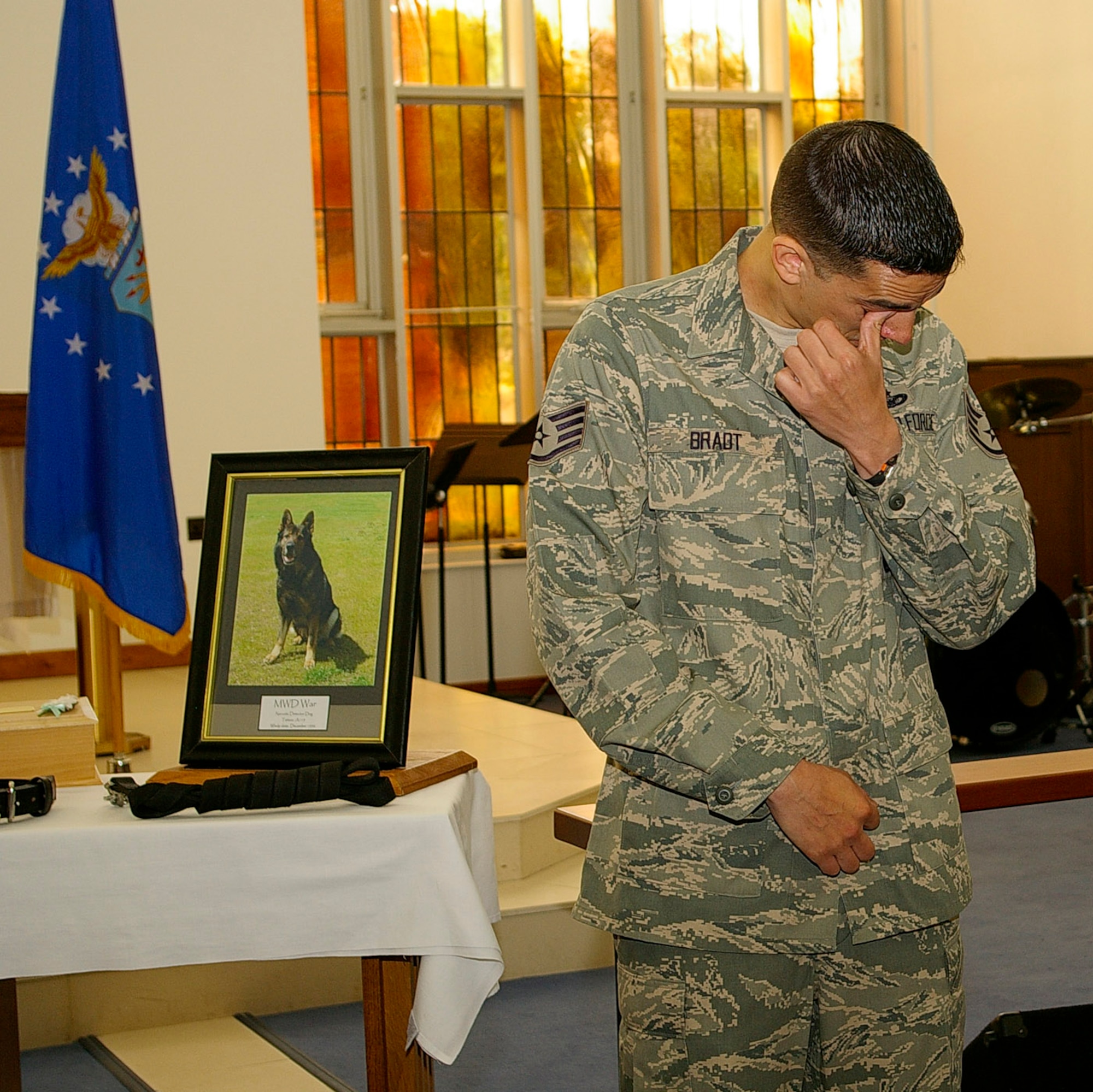 Staff Sgt. Phillip Bradt, 100th Security Forces Squadron, and last handler of Military Working Dog War, gets emotional during the playing of Taps at the memorial service for his canine partner, who died recently. Airmen and military working dogs from the 100th and 48th Security Forces Squadrons, wing leadership and personnel from RAF Mildenhall, attended the service to pay their respects to the popular MWD, War. (U.S. Air Force photo by Karen Abeyasekere)