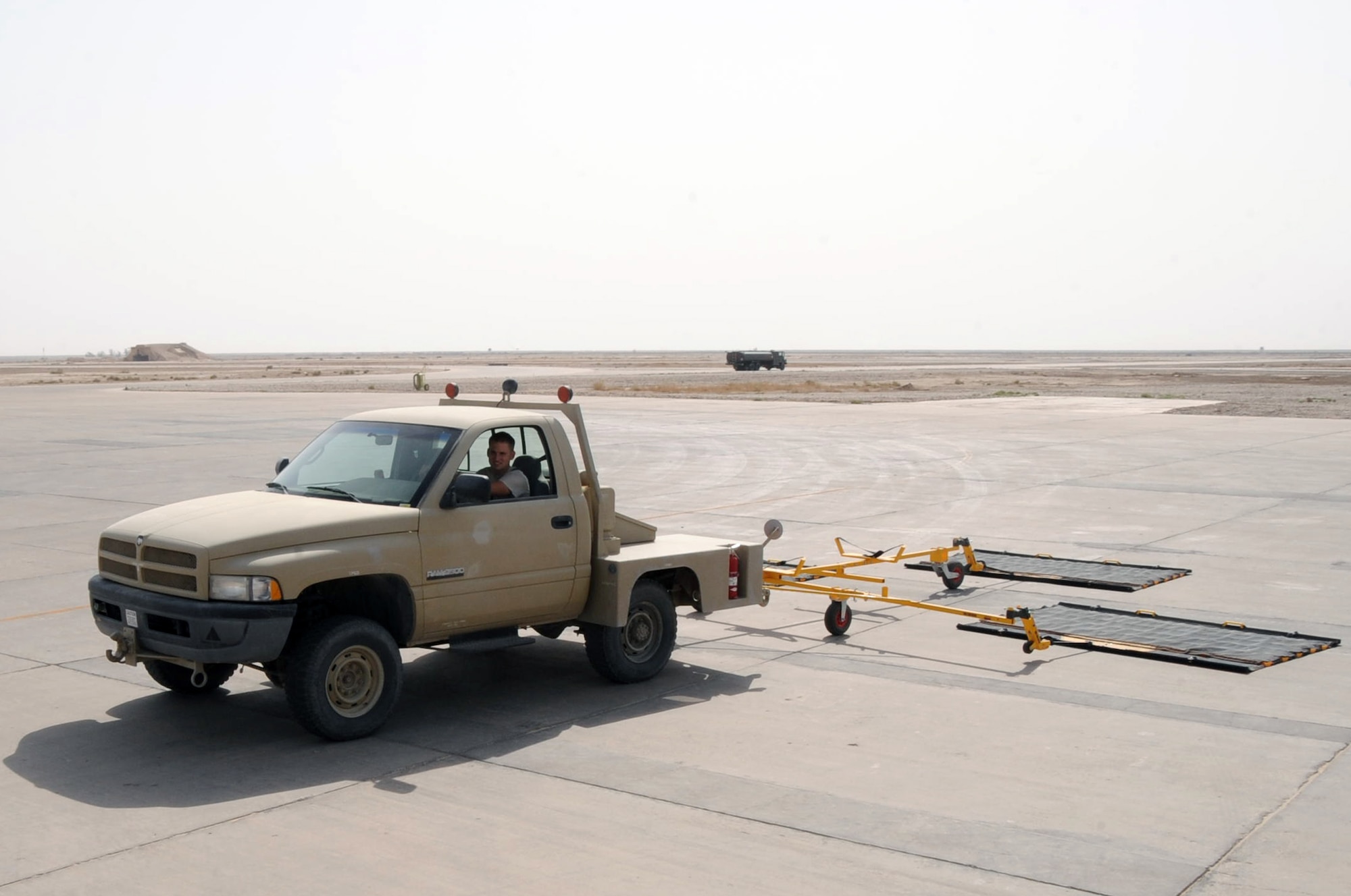 ALI BASE, Iraq -- Senior Airman Brian Pittman, transient alert specialist, uses the triple FOD Sweeper to combat Foreign Object Debris along the flightline here June 23. Airfield Management recently purchased the equipment as a part of the FOD program to keep the planes in the air undamaged while transporting personnel and cargo around the Area of Responsibility. Airman Pittman is deployed to the 407th Expeditionary Operations Support Squadron from Tyndall AFB, Fla. (U.S. Air Force photo/Tech. Sgt. Sabrina Johnson)