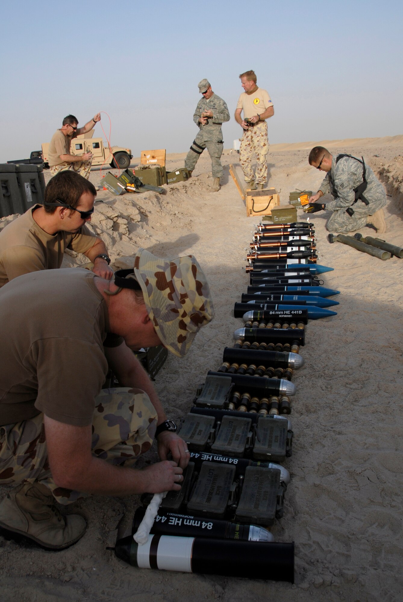 SOUTHWEST ASIA -- Australian Army ammunition technicians and members from the 386th Expeditionary Civil Engineer Squadron explosive ordnance disposal flight lay down plastic explosive over munitions during a controlled detonation June 20, 2008, at an EOD range in the Persian Gulf Region.  The joint detonation also provided an opportunity for the coalition forces to enhance relations while learning some of the slight differences in operating procedures.  (U.S. Air Force photo/ Staff Sgt. Patrick Dixon)