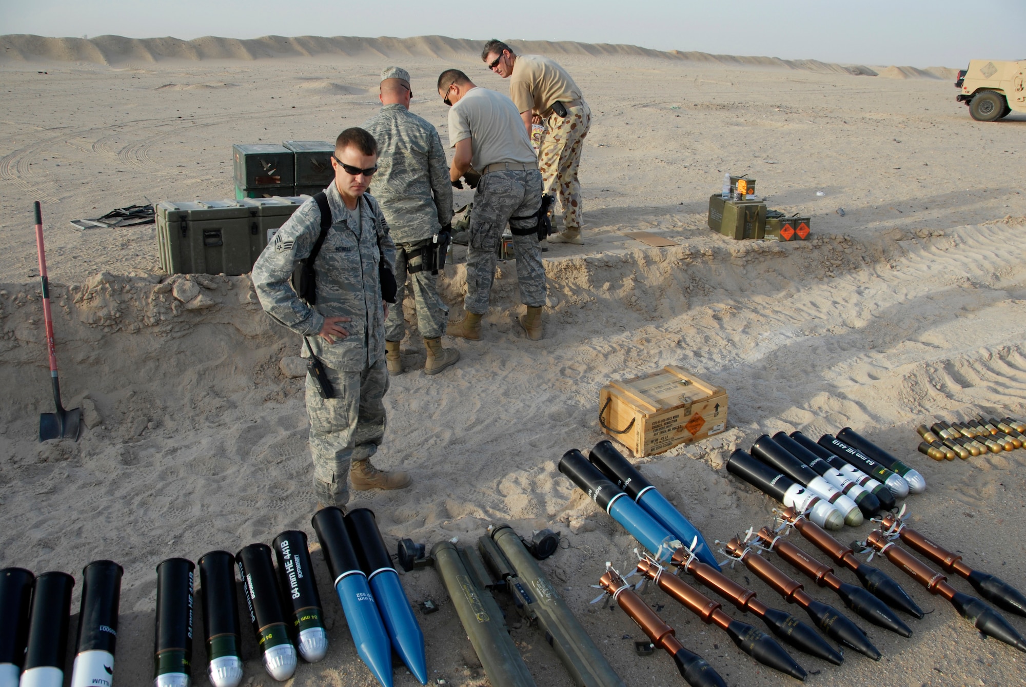 SOUTHWEST ASIA -- Senior Airman Charles Howell, (front center), from the 386th Expeditionary Civil Engineer Squadron explosive ordnance disposal flight, looks over the munitions that are about to be destroyed, while other members from his EOD flight and Australian Army ammunition technicians prepare light anti-armor weapon rockets for disposal during a controlled detonation June 20, 2008, at an explosive ordinance disposal range in the Persian Gulf Region.  The joint detonation also provided an opportunity for the coalition forces to enhance relations while learning some of the slight differences in operating procedures.  (U.S. Air Force photo/ Staff Sgt. Patrick Dixon)