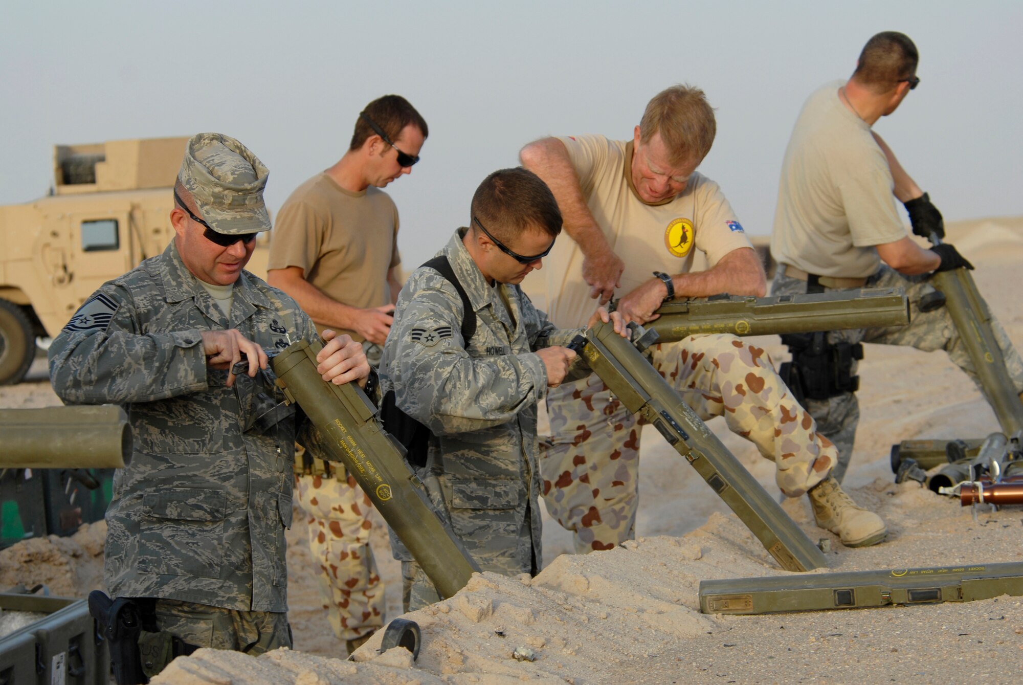 SOUTHWEST ASIA -- Members from the 386th Expeditionary Civil Engineer Squadron explosive ordnance disposal flight and Australian Army ammunition technicians prepare light anti-armor weapon rockets for disposal during a controlled detonation June 20, 2008, at an EOD range in the Persian Gulf Region.  The controlled detonation is destroying unserviceable munitions. The joint detonation also provided an opportunity for the coalition forces to enhance relations while learning some of the slight differences in operating procedures. (U.S. Air Force photo/ Staff Sgt. Patrick Dixon)