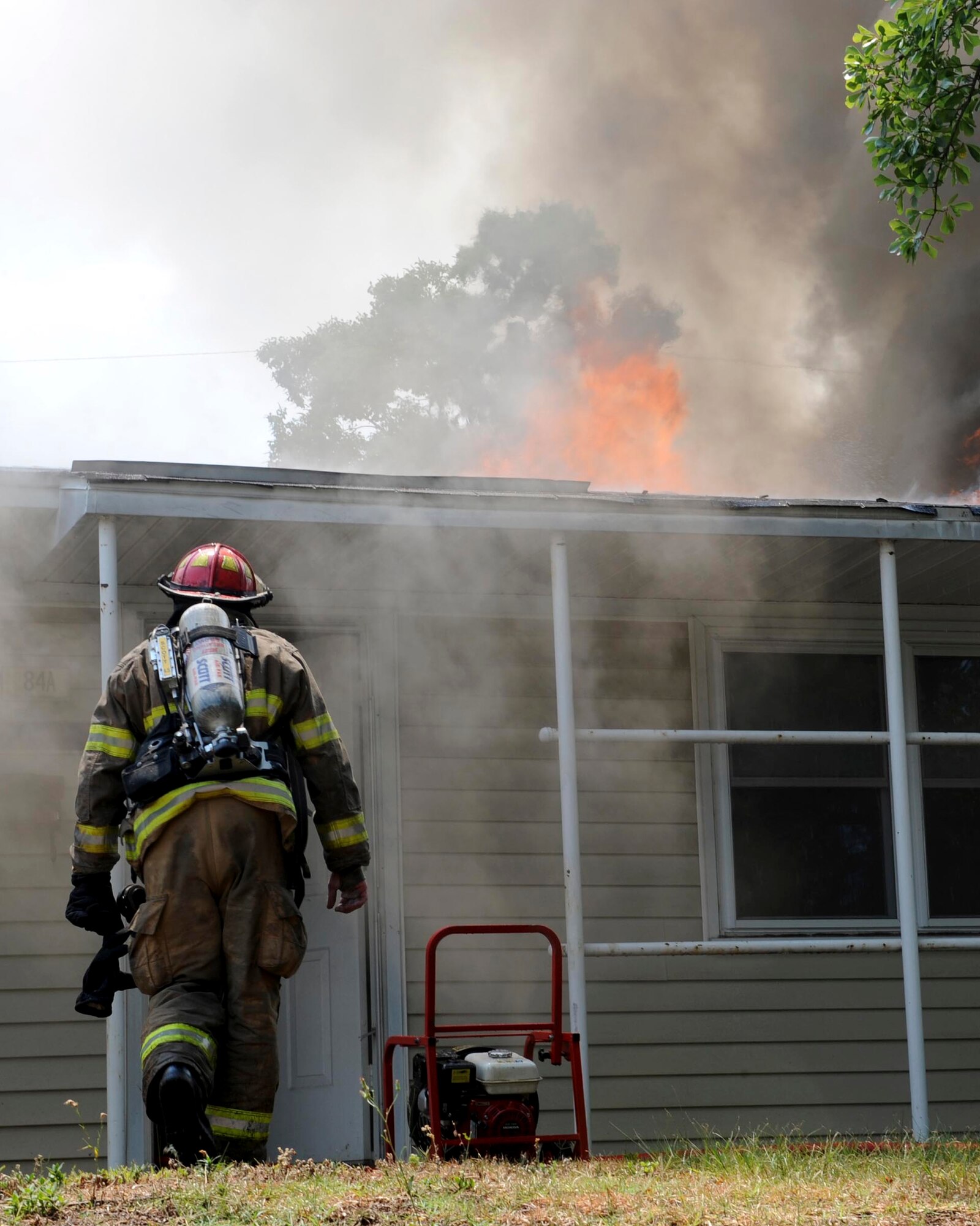 SHAW AIR FORCE BASE, S.C.-- A Shaw firefighter marches back into the burning house to continue battling the blaze June 20. The house is in an area marked for demolition and was not occupied. (U.S. Air Force Photo/Staff Sgt. Henry Hoegen)