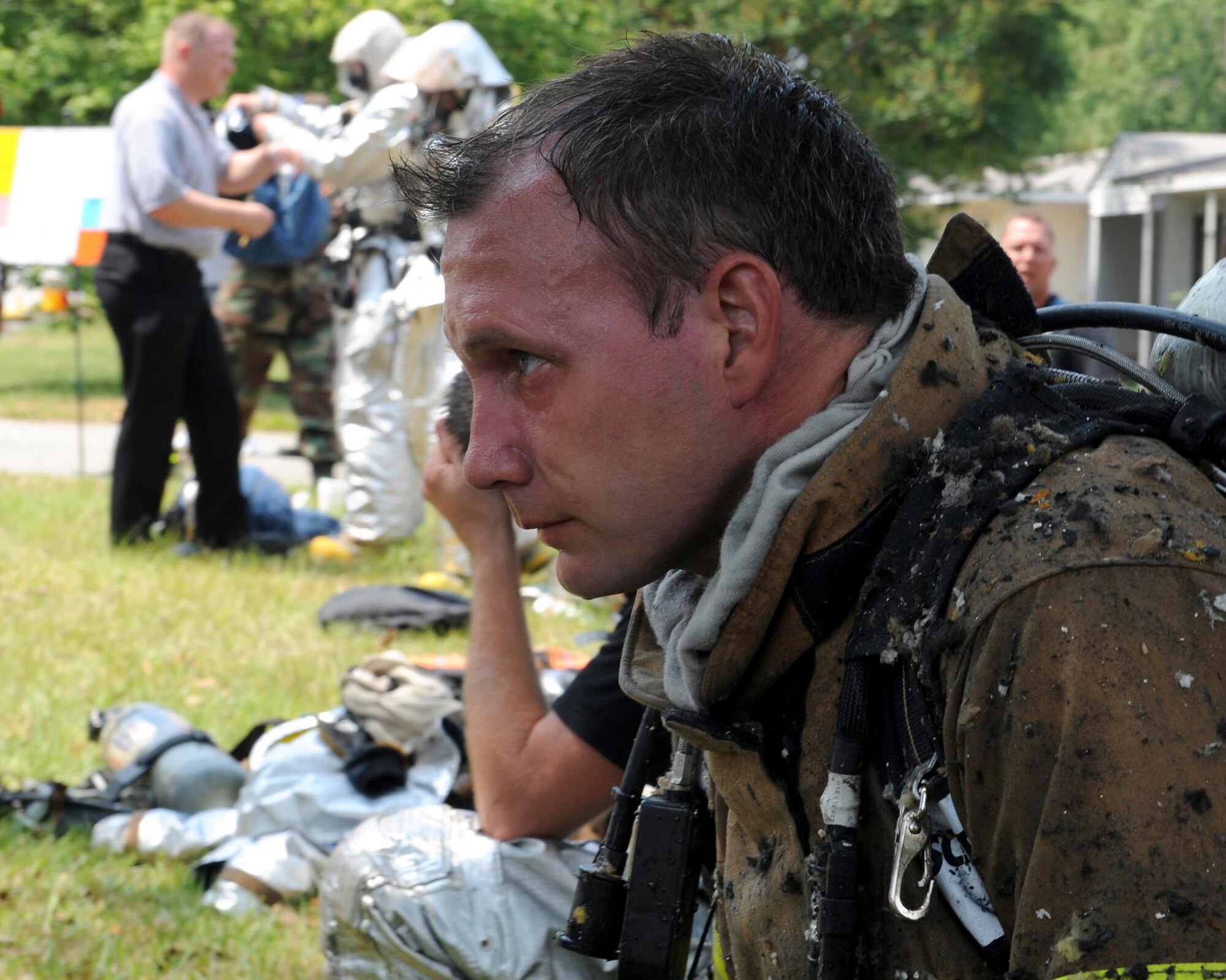 SHAW AIR FORCE BASE, S.C.-- Greg Farley, 20th Civil Engineering Squadron fire captain, rests after exiting a house fire while the controlled chaos continues on behind him June 20. The house is in an area marked for demolition and was not occupied. (U.S. Air Force Photo/Staff Sgt. Henry Hoegen)