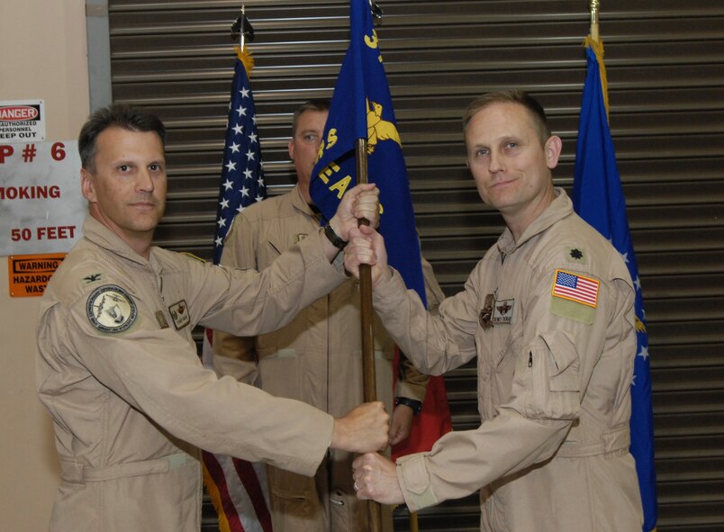 Lt. Col. Dwight Dorau receives the guidon of the 22nd Expeditionary Air Refueling Squadron from Col. Randall Ogden, 376th Expeditionary Operations Group commander, in a change of command ceremony at Manas Air Base, Kyrgyzstan, June 16. Colonel Dorau is deployed to the base for 120 days and will command a squadron of approximately 12 KC-135R Stratotanker aerial refuelers and 80 Airmen to conduct strategic refueling of Coalition aircraft supporting military operations in Afghanistan. He is deployed from Royal Air Force Mildenhall, United Kingdom, where he serves as commander of the 100th Operations Support Squadron.
