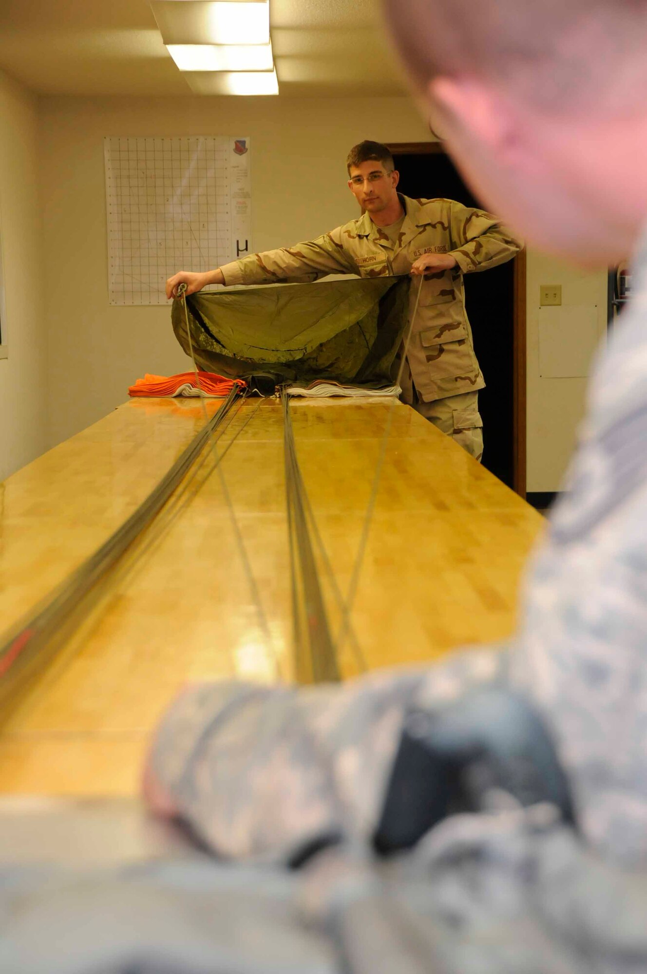 SOUTHWEST ASIA—Staff Sgt. John Horn and Staff Sgt. Craig Hall 379th Expeditionary Operations Support Squadron, air the parachute and maintain line continuity June 14. (U.S. Air Force photo/ Senior Airman Domonique Simmons)