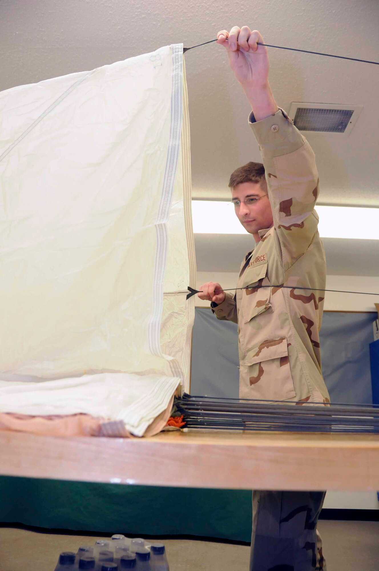 SOUTHWEST ASIA--Staff Sgt. John Horn 379th Expeditionary Operations Support Squadron aircrew flight equipment technician airs the canopy of a parachute June14. (U.S. Air Force photos/ Senior Airman Domonique Simmons)