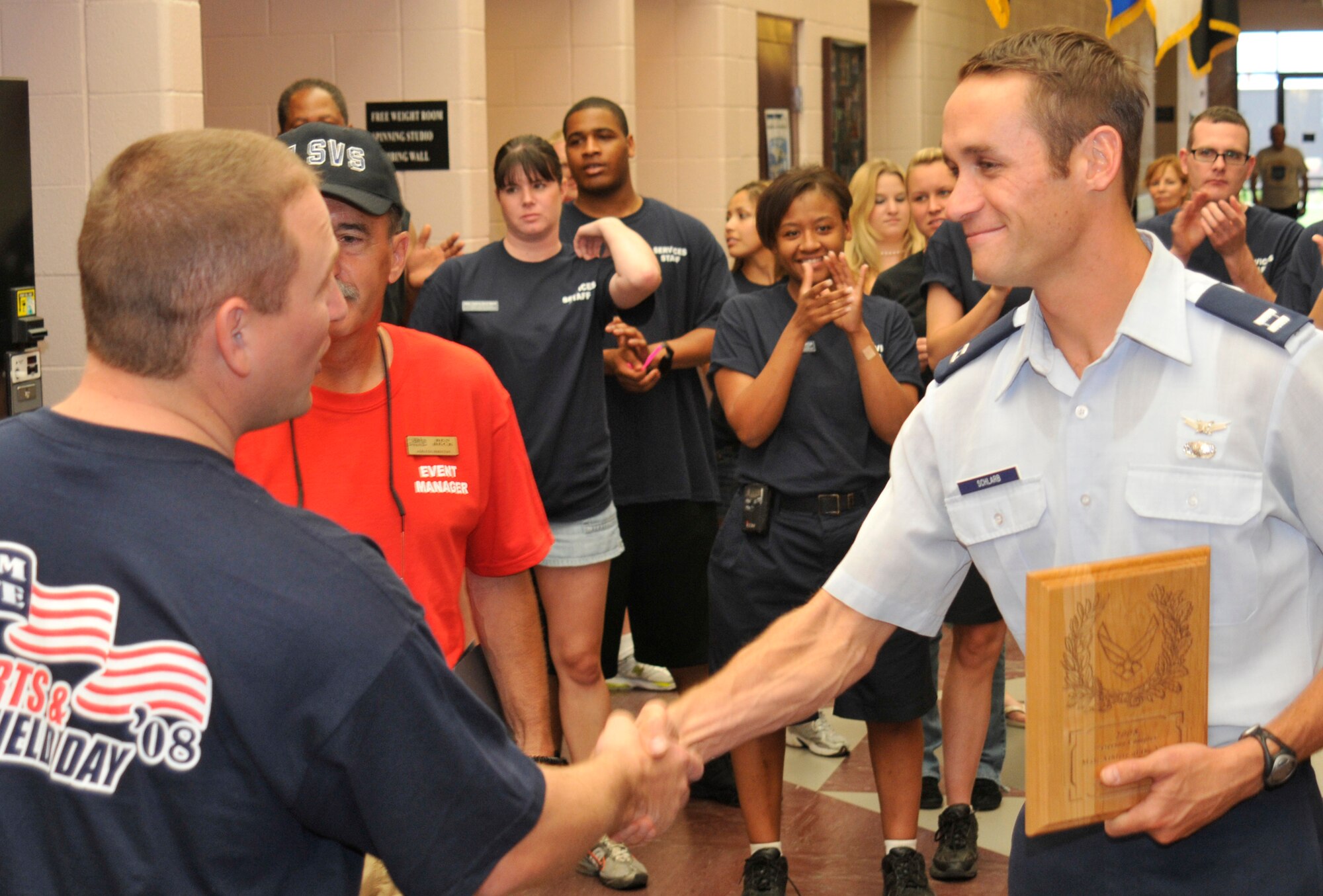 Capt. Jason Schlarb is presented a plaque for superior sports performance during Sports Day activities June 19 at Peterson Air Force Base, Colo. Sports Day is an annual event that gives members of the wing time to build teamwork skills and boost morale. The event also offers the wing a chance to flex its “Fit to Fight” muscles. (U.S. Air Force photo/Larry Hulst)