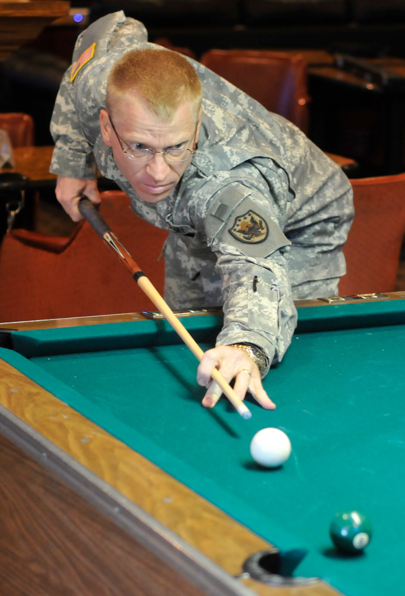 An Army Soldier looks to make his shot while playing billiards during Sports Day activities June 19 at Peterson Air Force Base, Colo. Sports Day is an annual event that gives members of the wing time to build teamwork skills and boost morale. The event also offers the wing a chance to flex its “Fit to Fight” muscles. (U.S. Air Force photo/Larry Hulst)