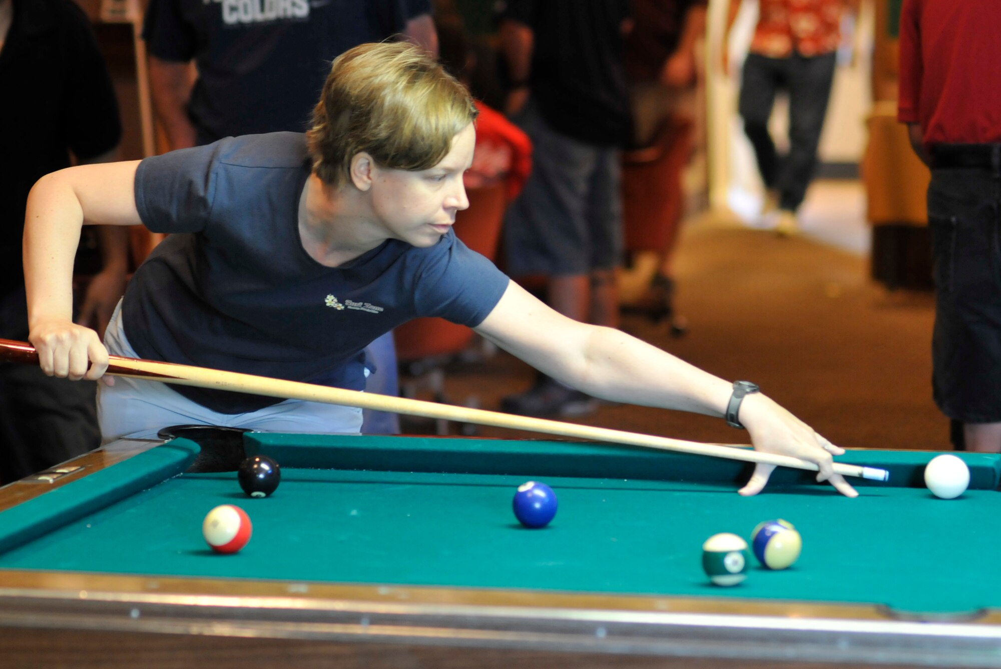 A 21st Space Wing member looks for a corner pocket shot while playing billiards during Sports Day activities June 19 at Peterson Air Force Base, Colo. Sports Day is an annual event that gives members of the wing time to build teamwork skills and boost morale. The event also offers the wing a chance to flex its “Fit to Fight” muscles. (U.S. Air Force photo/Larry Hulst)