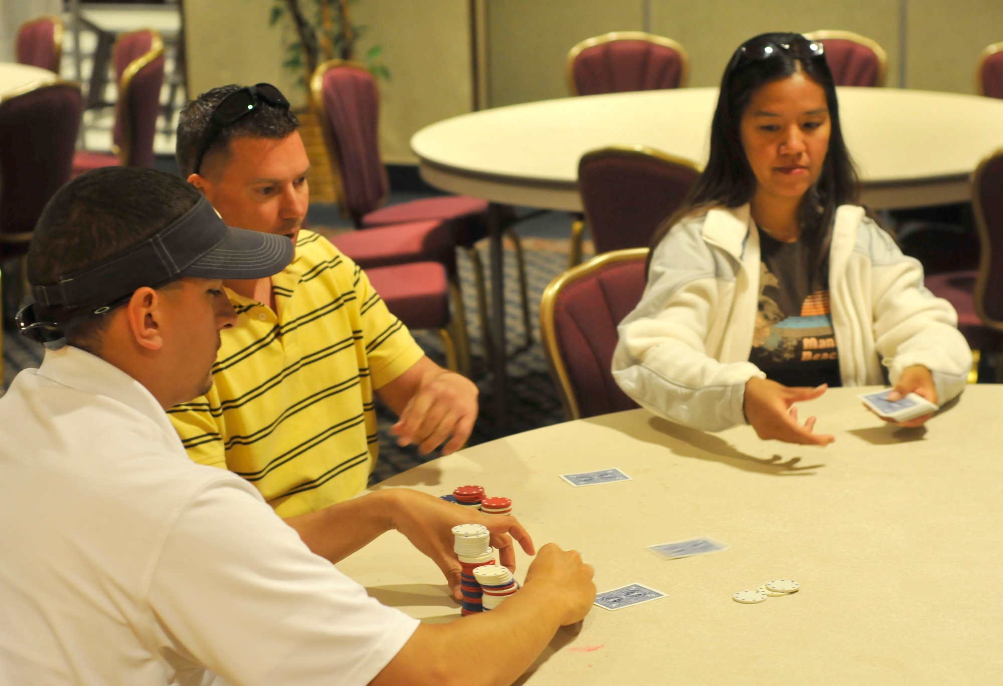 Members of the 21st Space Wing try their hand at Texas Hold ‘Em poker during Sports Day activities June 19 at Peterson Air Force Base, Colo. Sports Day is an annual event that gives members of the wing time to build teamwork skills and boost morale. The event also offers the wing a chance to flex its “Fit to Fight” muscles. (U.S. Air Force photo/Larry Hulst)