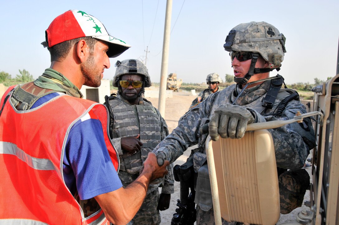 U.S. Army 1st Lt. Forest Davis thanks a member of Sons of Iraq, a citizens security group, for the group's work in stopping enemy attacks around the Tigris River Valley, June 20, 2008. Davis is a platoon leader with the 2nd Battalion, 320th Field Artillery Regiment, 1st Brigade Combat Team, 101st Airborne Division.