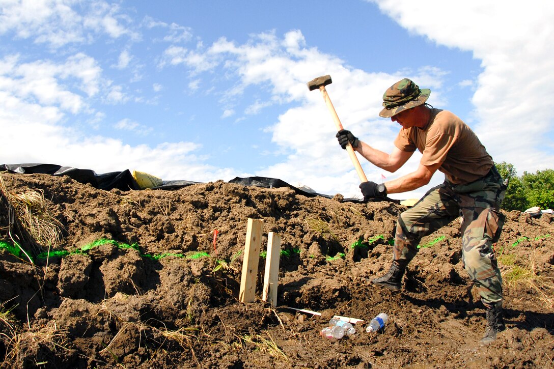 U.S. Air Force Tech. Sgt. Don Reay hammers a stake into the ground to reinforce the Indian Graves levee near Quincy, Ill., June 22, 2008. Reay is a member of the Illinois Air National Guard. 
