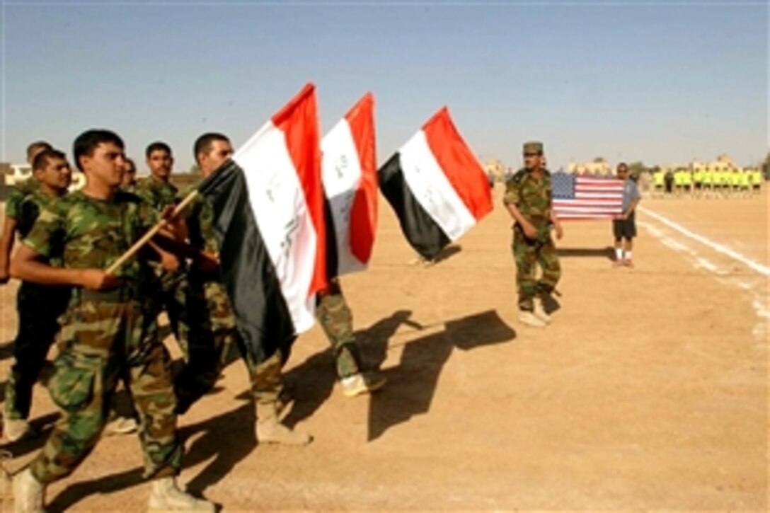 Members of  the Multaka Sons of Iraq perform a pass and review during the opening ceremony before the kick-off of a soccer game between the their soccer team and a team of U.S. Army soldiers in Multaka, Iraq, June 19, 2008. The soldiers are assigned to the 10th Mountain Division's 1st Battalion, 87th Infantry Regiment. 