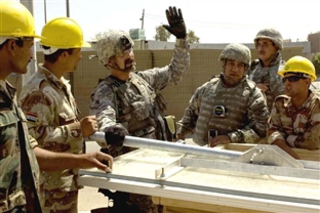 Darryl B. Steadman, center left, a U.S. civilian working with the Military Assistance Team, Iraqi Assistance Group, explains to engineers in the Iraqi Army's 6th Division the proper position for a mounting post for a solar light panel, June 19, 2008. The solar lights are an initative of the U.S. Army's 4th Infantry Division, which hopes the move will reduce the strain on Baghdad's electrical system while lighting checkpoints.