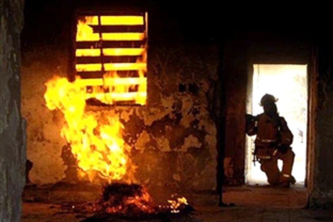 Fire Chief David Sessions, a U.S. civilian working for the Camp Slayer Fire Department in Iraq, monitors a fire in the camp's training facility building during a Mass Casualty Exercise, June 20, 2008. 