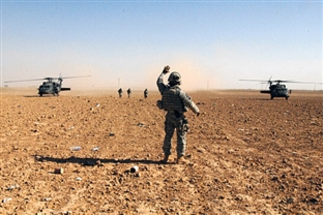 U.S. Army Lt. Col. Christopher S. Vanek directs passengers from two U.S Army UH-60 Blackhawks to walk in his direction on a field in Multaka, Iraq, June 19, 2008. Vanek is commander of the 10th Mountain Division's 1st Battalion, 87th Infantry Regiment. 