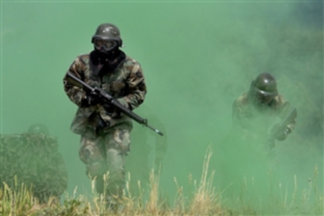 U.S. Air Force Academy cadets storm through a smoke grenade as they attempt to secure the Military Operations Urban Terrain village during the 71-day summer training schedule, June 19, 2008, at the academy in Colorado Springs, Colo. About 1,200 cadets are going through intensive training this summer.