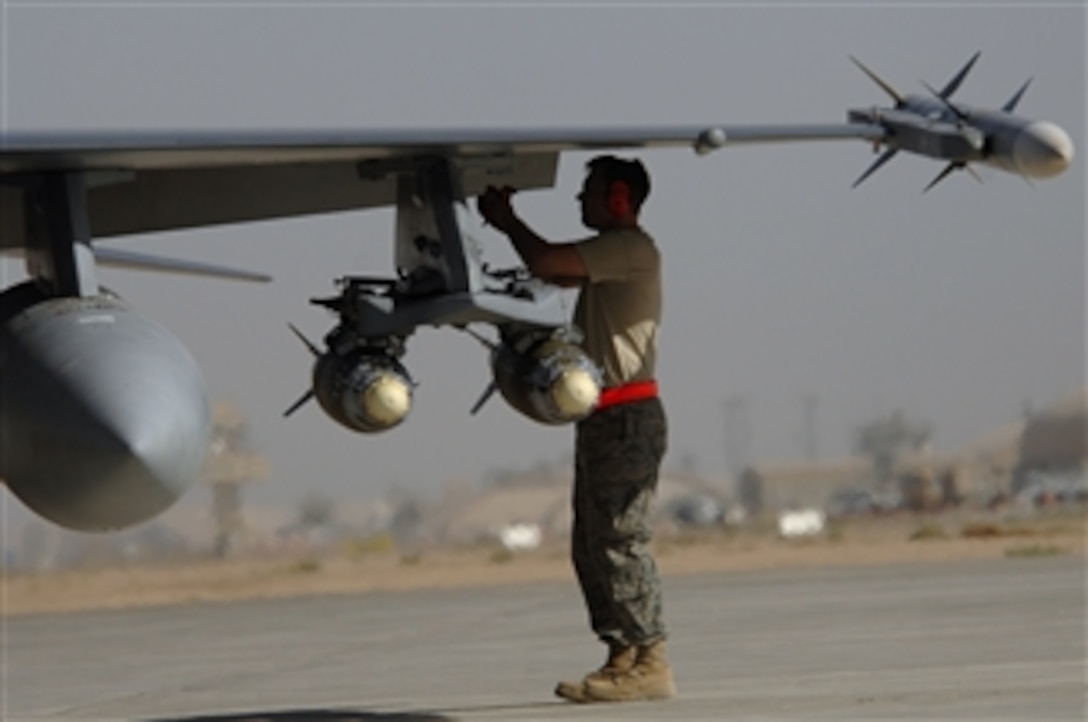 A U.S. Air Force airman assigned to the 332nd Expeditionary Aircraft Maintenance Squadron arms an F-16 Fighting Falcon aircraft by removing the safety pins at Joint Base Balad, Iraq, on June 18, 2008.  The F-16 pilots provide close air support to ground forces during combat missions all over Iraq.  