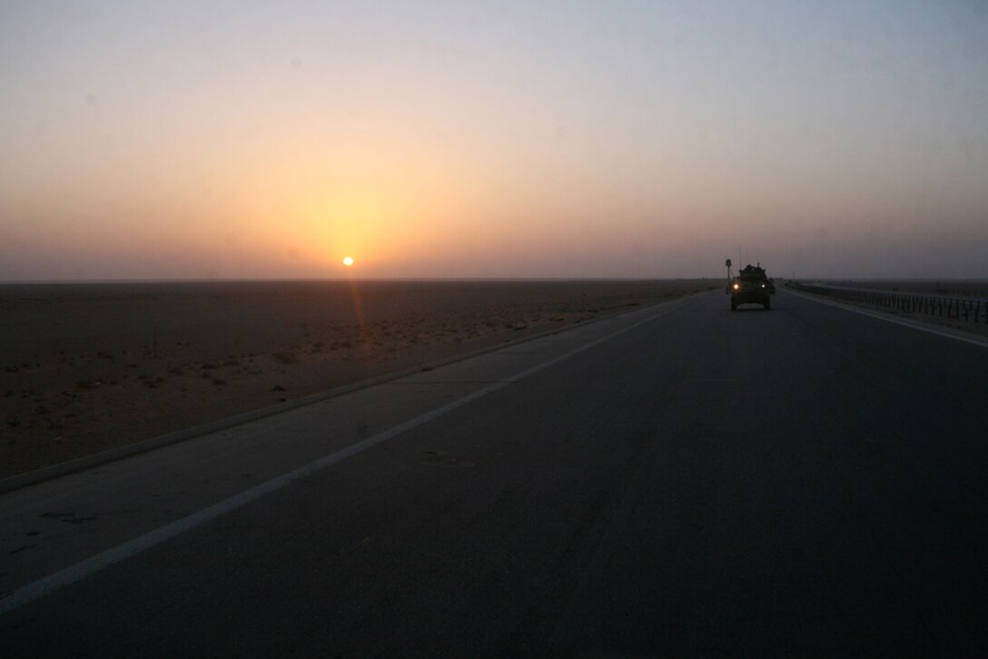 A light armored vehicle with Alpha Company, 2nd Light Armored Reconnaissance Battalion, Regimental Combat Team 5 drives down an Iraqi highway on its way to Nukhayb, Iraq, during an initial meeting with the town leaders, June 23. The Marines with Alpha Co. visited the village to establish a partnership.  The company and Seabees with Naval Mobile Construction Battalion 17 plan to help the town repair the well that supplies the town with water and the generators that provide the town with power.::r::::n::