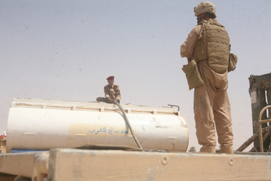 Capt. Steven M. Sutey, 31, commanding officer of Alpha Company, 2nd Light Armored Reconnaissance Battalion, Regimental Combat Team 5, speaks with the Iraqi police chief of Nukhayb, Iraq, during an initial meeting with leaders of the town, June 23. The company plans to assist the Iraqi police and create a partnership with the leaders.::r::::n::