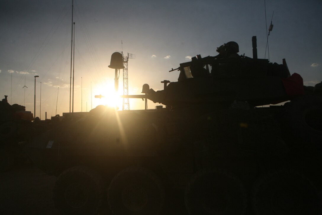 Pfc. Michael J. Rappa, a motor vehicle operator with Headquarters and Service Company, 2nd Light Armored Reconnaissance Battalion, Regimental Combat Team 5, watches while a water tank in the city of Nukhayb, Iraq, is being refilled June 23.  Alpha Co. brought the town water because the town's well is in need of repair.  The Marines and Seabees with Naval Mobile Construction Battalion 17 plan to help the town repair the well and the generators that supply the town with power.::r::::n::
