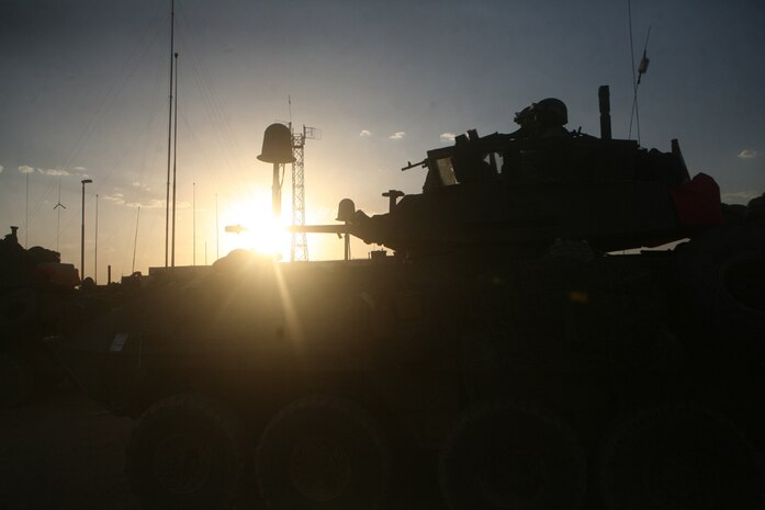 Pfc. Michael J. Rappa, a motor vehicle operator with Headquarters and Service Company, 2nd Light Armored Reconnaissance Battalion, Regimental Combat Team 5, watches while a water tank in the city of Nukhayb, Iraq, is being refilled June 23.  Alpha Co. brought the town water because the town's well is in need of repair.  The Marines and Seabees with Naval Mobile Construction Battalion 17 plan to help the town repair the well and the generators that supply the town with power.::r::::n::