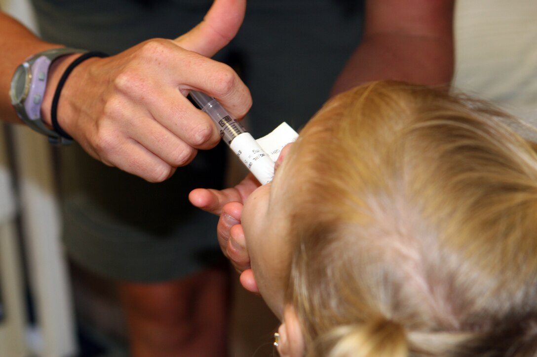 Kathy May gives her daughter Laina medicine at the Kapi'olani Medical Center for Women and Children Monday. The two-year-old receives pain medication to help assuage the pain she feels from burns to her hands and right foot she received June 14.