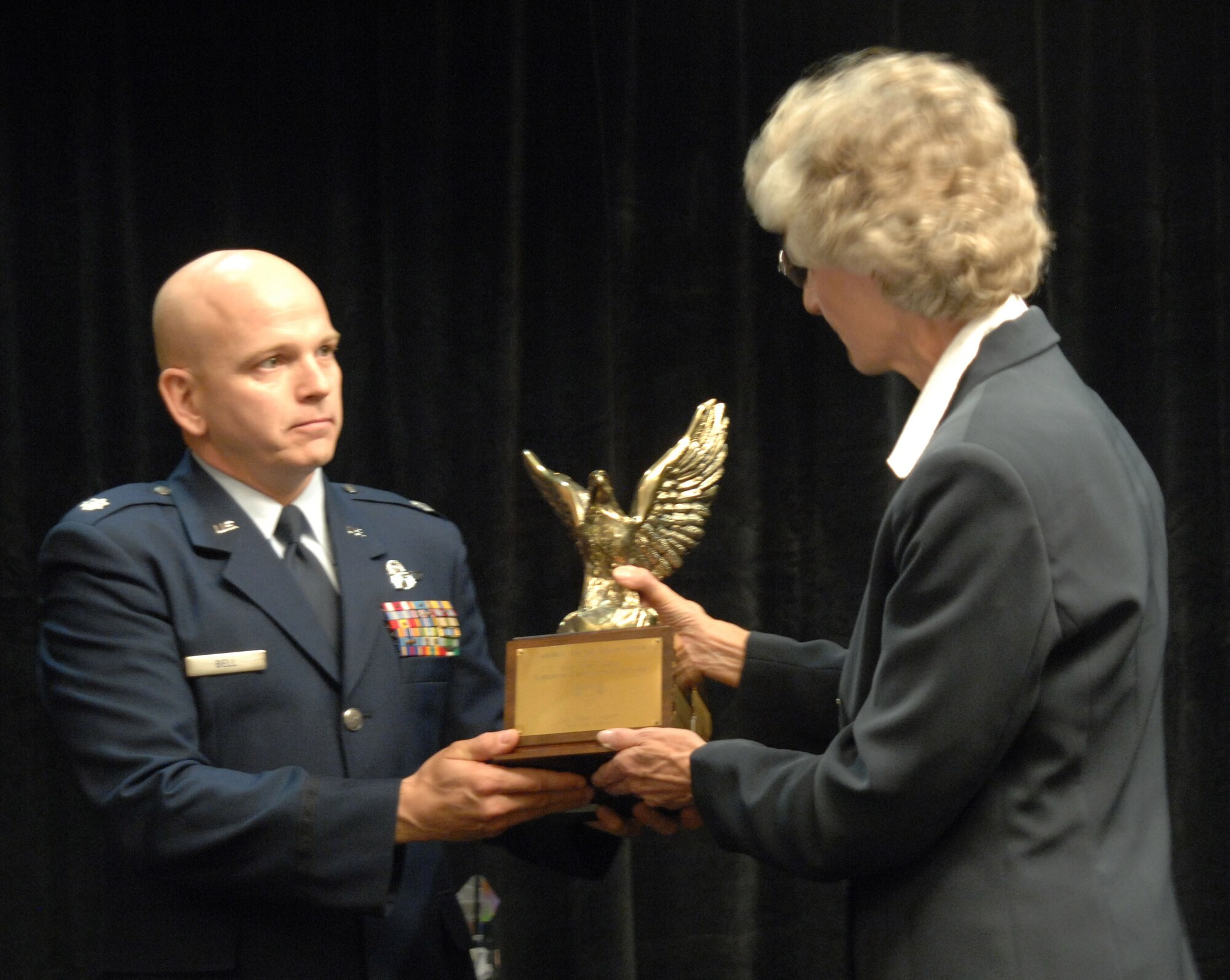 EXCELLENCE: Lieutenant Colonel Thomas A. Bell, left, from the 729th Airlift Squadron, accepts the Aircrew Excellence Award presented by Nancy Driscoll, President of the Bob Hope Chapter, Air Force Association at March ARB, during the 10th Annual Raincross Trophy Dinner held at the Riverside Convention Center. (U.S. Air Force photo by Senior Master Sgt. Kim Allain)