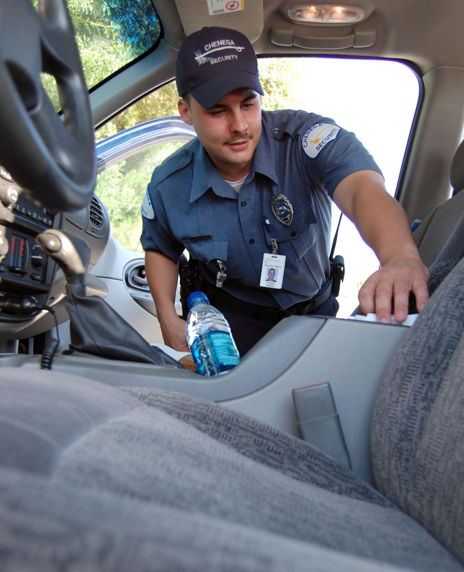 LAUGHLIN AIR FORCE BASE, Texas – Robert Negley, a contracted security guard with the 47th Security Forces Squadron, inspects a car during a random vehicle inspection at the main gate here June 24. Security guards protect the base here by ensuring all individuals that come on base have proper identification, car insurance and no illegal possessions.  (U.S. Air Force photo by Airman 1st Class Sara Csurilla)