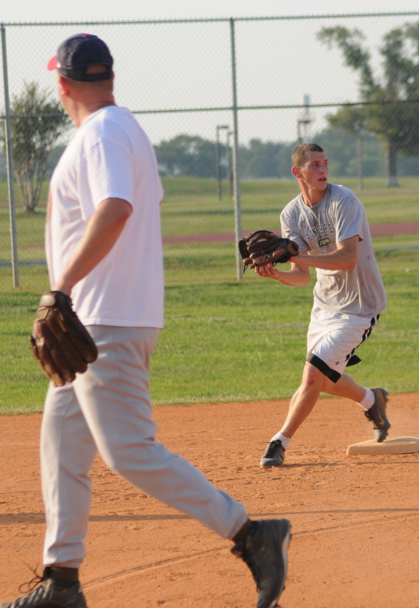 Pitcher Kenneth Williams, left, 81st Supply-Transpor-tation Squadron, steps to the side as second baseman Joe Lockman tags second base and looks to first for a double play during a June 18 intramural softball game with the Marine Corps Detachment.  The 81st SUPS-TRANS won, 18-6, moving the team into fourth place in the American League behind the 336th Training Squad-ron, 8-2, and the 335th TRS-A and 332nd TRS, both 8-3.  MARDET fell to 5-4.  (U.S. Air Force photo by Kemberly Groue)