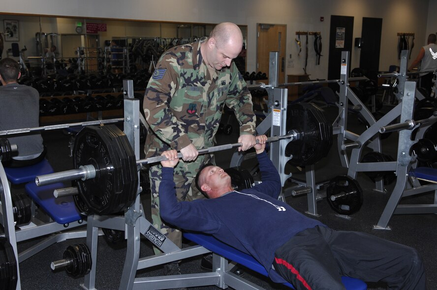 MINOT AIR FORCE BASE, N.D. -- Tech. Sgt. Steven Spinola, 5th Force Support Squadron exercise specialist, spots Tech. Sgt. Jeff Hammonds, 791st Missile Security Forces Squadron flight chief, on a bench press exercise at the McAdoo Sports and Fitness Center here June 23. (courtesy photo)