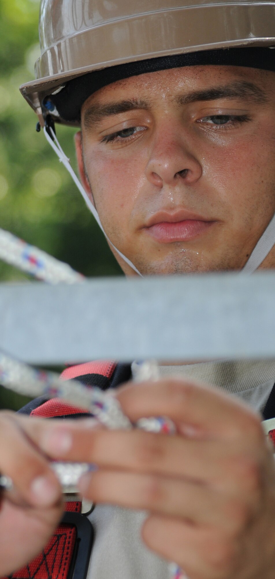 Airman Basic Timothy Collar, a student in the 338th TRS, practices tying a bow line knot before climbing the tower behind Maltby Hall, June 18.  (U.S. Air Force photo by Kemberly Groue)
