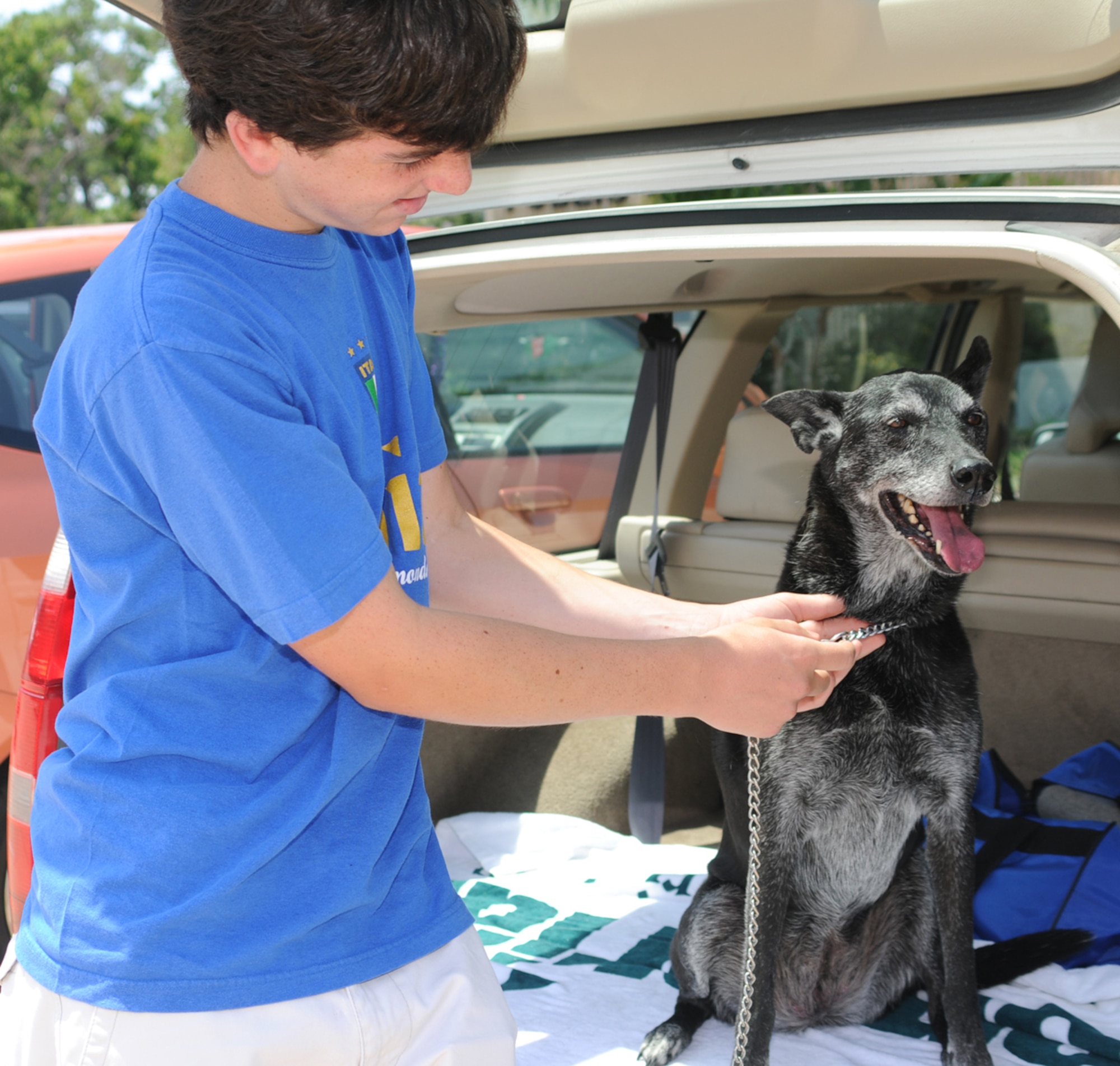 Michael Gargiulo, 14, loads his family’s dog, Pepper, into the car.  There won’t be a pet shelter available on base if a hurricane should threaten the area, so Keesler families must make other arrangements, either finding a kennel to care for them or taking them along during an evacuation.  Michael’s parents are retired Lt. Col. Robert and Jackie Gargiulo of Long Beach.  (U.S. Air Force photo by Kemberly Groue)