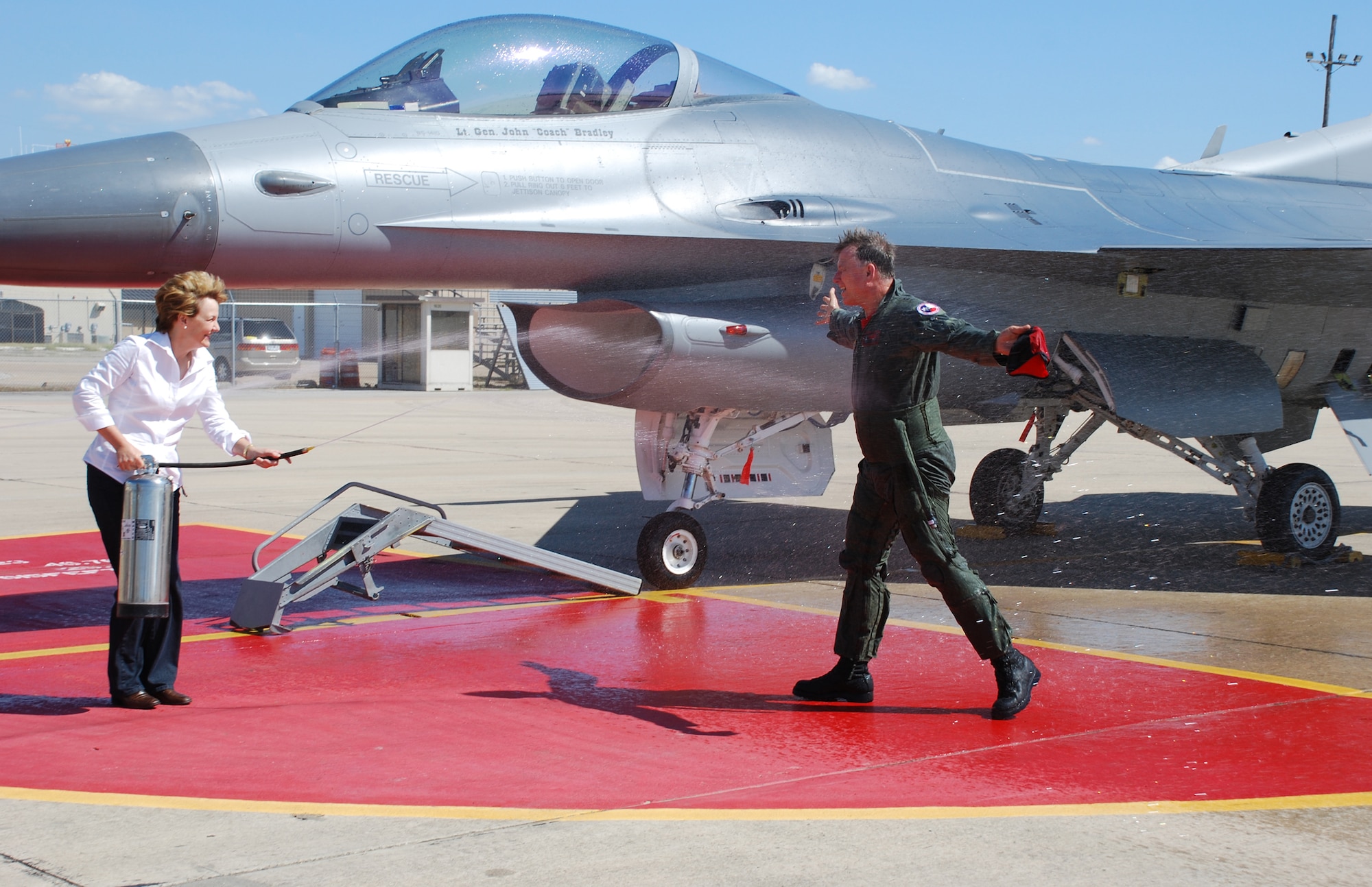 Lt Gen John "Coach" Bradley, Air Force Reserve Command commander, takes a soaking from Mrs. Jan Bradley Friday, June 20, 2008, following his final F-16 flight at the Naval Air Station Fort Worth Joint Reserve Base Carswell Field, Texas. General Bradley completed his flying career logging in over 7053 total flight hours, many with the 457th Fighter Squadron Fighting Spads here. (U.S Air Force Photo/Tech. Sgt. Julie Briden-Garcia)