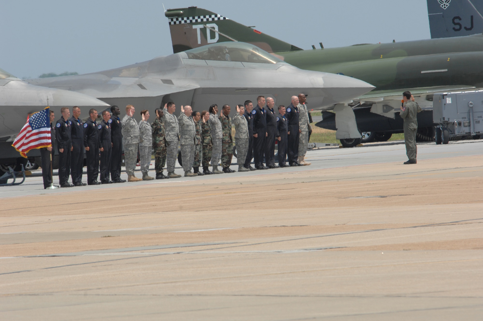 LANGLEY AIR FORCE BASE, Va. - Maj. Paul "Max" Moga, the first F-22A Raptor Demonstration Team pilot, leads 10 Langley Airmen in the re-enlistment oath during a ceremony here at AirPower over Hampton Roads June 22. With the re-enlistment, the Airmen volunteered to serve another four or six years in the Air Force. (U.S. Air Force photo/Tech. Sgt. April Wickes)