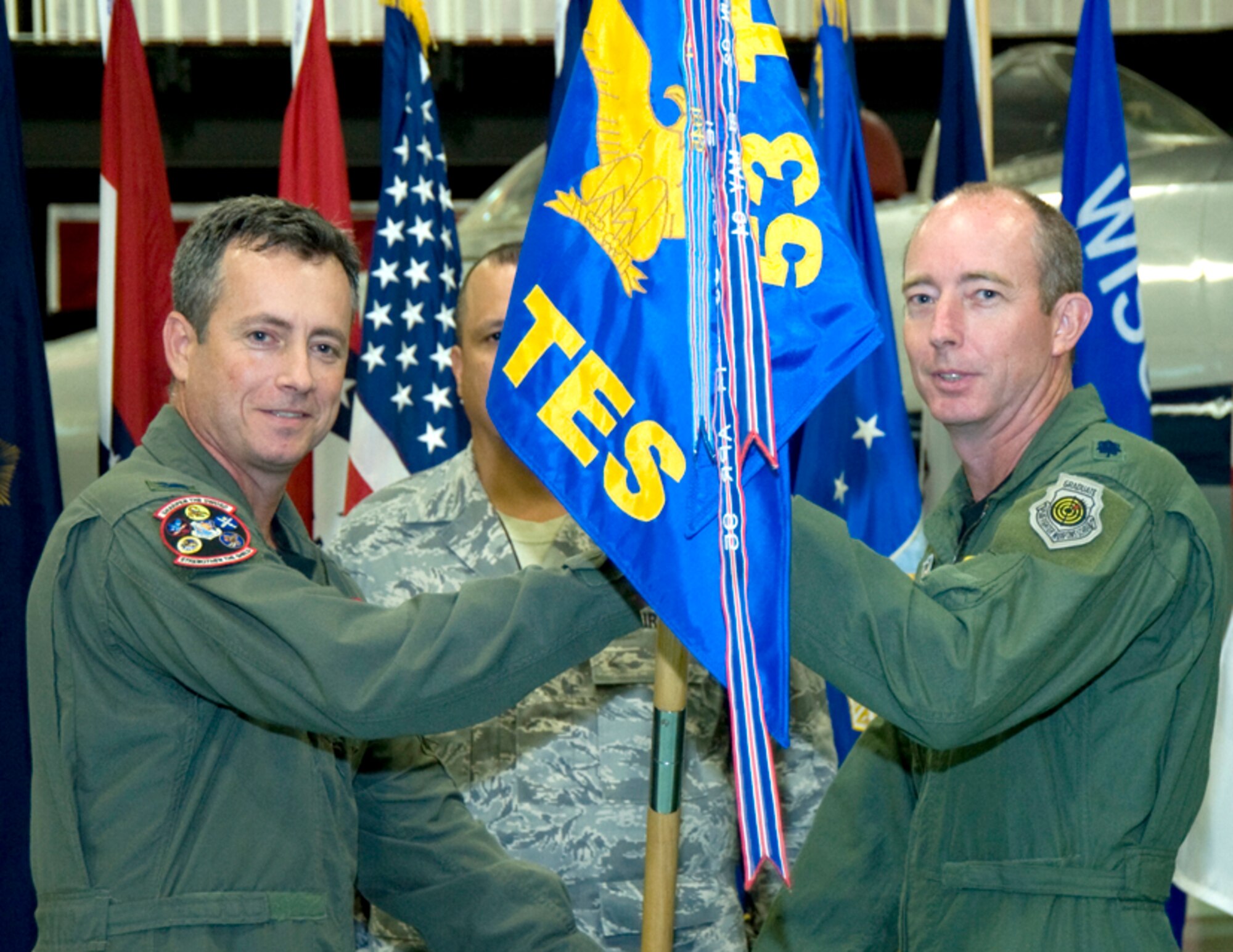 Lt. Col. Greg Wilson, takes the 28th Test and Evaluation Squadron quidon from Col. Thomas Berghoff, 53d Test Management Group commander, June 20 during a change of command ceremony at the Air Armament Center.  Colonel Wilson took the 28th TES reins from Lt. Col. Henri Castelain.  U.S. Air Force photo.