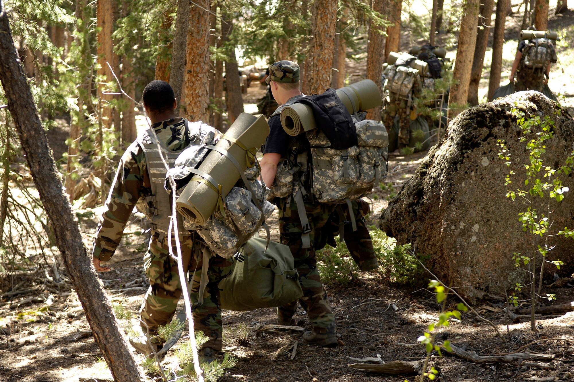 Air Force Academy cadets enter a wooded area June 9, where they will set up camp in Saylor Park, Colo. More than 600 cadets are being trained as instructors in survival, evasion, resistance and escape tactics during the 2008 summer period. (U.S. Air Force photo/Mike Kaplan)