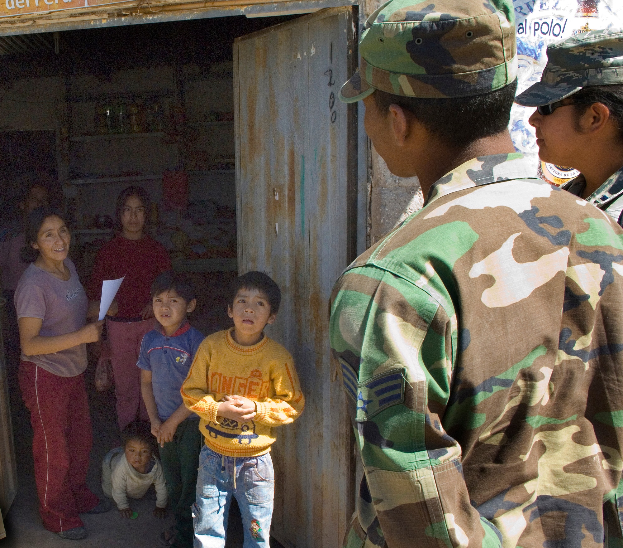 Senior Airman Cecillio Cabezas passes out flyers and translates for Peruvain families announcing free medical, dental and eye care June 22 at a local schoolhouse in Ayacucho, Peru. American servicemembers are providing medical care in support of  New Horizons-Peru 2008, a U.S. and Peruvian partnered humanitarian mission set on providing relief to underprivileged Peruvians. Airman Cecillio Cabezas is assigned to the 1st Civil Engineer Squadron at Langley Air Force Base, Va. (U.S. Air Force photo/Staff Sgt. Bennie J. Davis III)