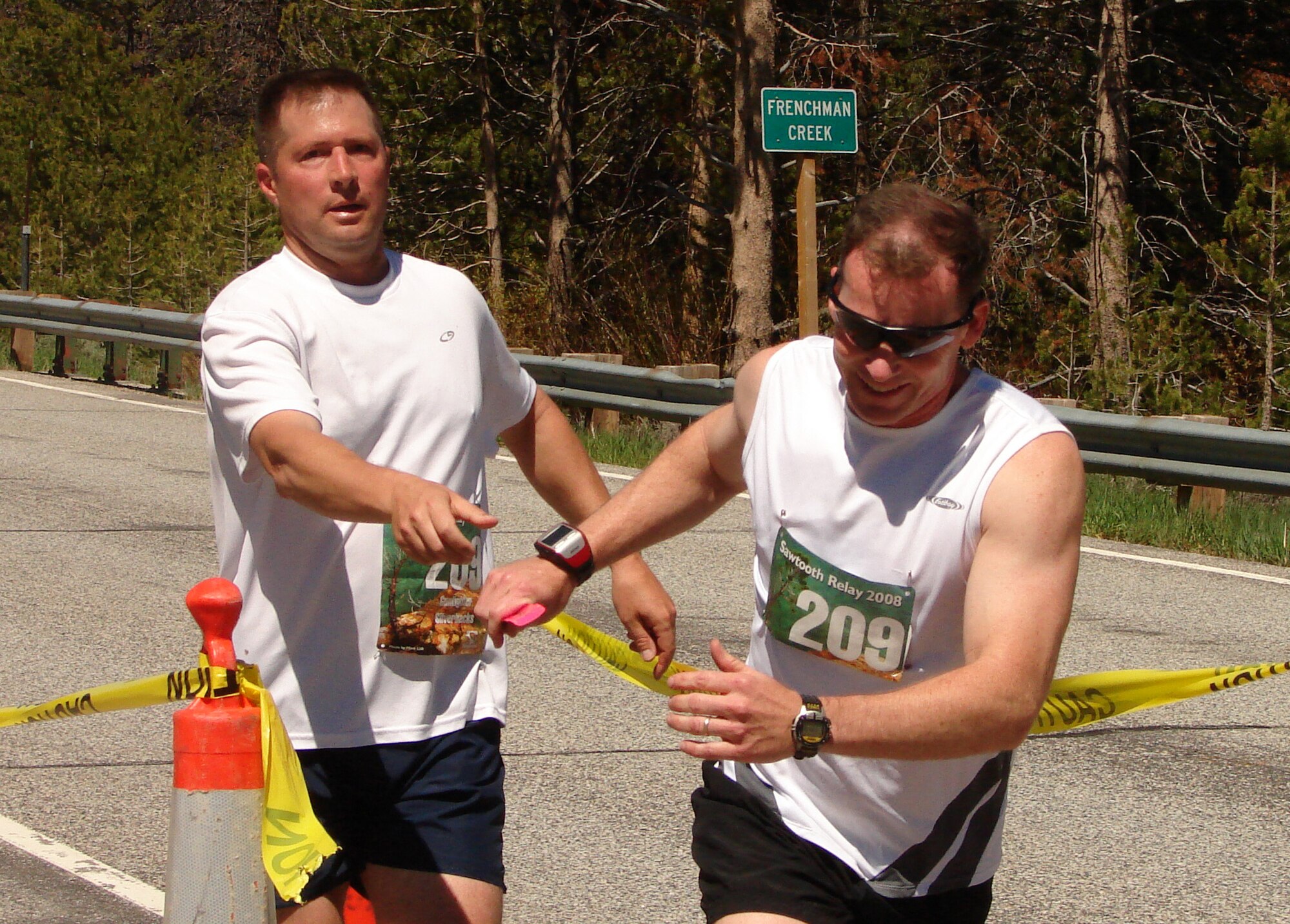 MOUNTAIN HOME AIR FORCE BASE, Idaho -- Lt. Col. Timothy Wood, 366th Civil Engineer Squadron commander, hands off the baton to Maj. Jim Tanner, 366th Aeromedical Dental Squadron flight commander, in the nearly 62 mile 17th Annual Sawtooth Relay June 14. The relay began at Stanley Elementary School, in Stanley, Idaho, and ended at Atkinson Park, in Ketchum, Idaho, each participant completed two of the 12 legs. Both ran on the Gunfighter Silverback team. (U.S. Air Force photo/Courtesy photo)