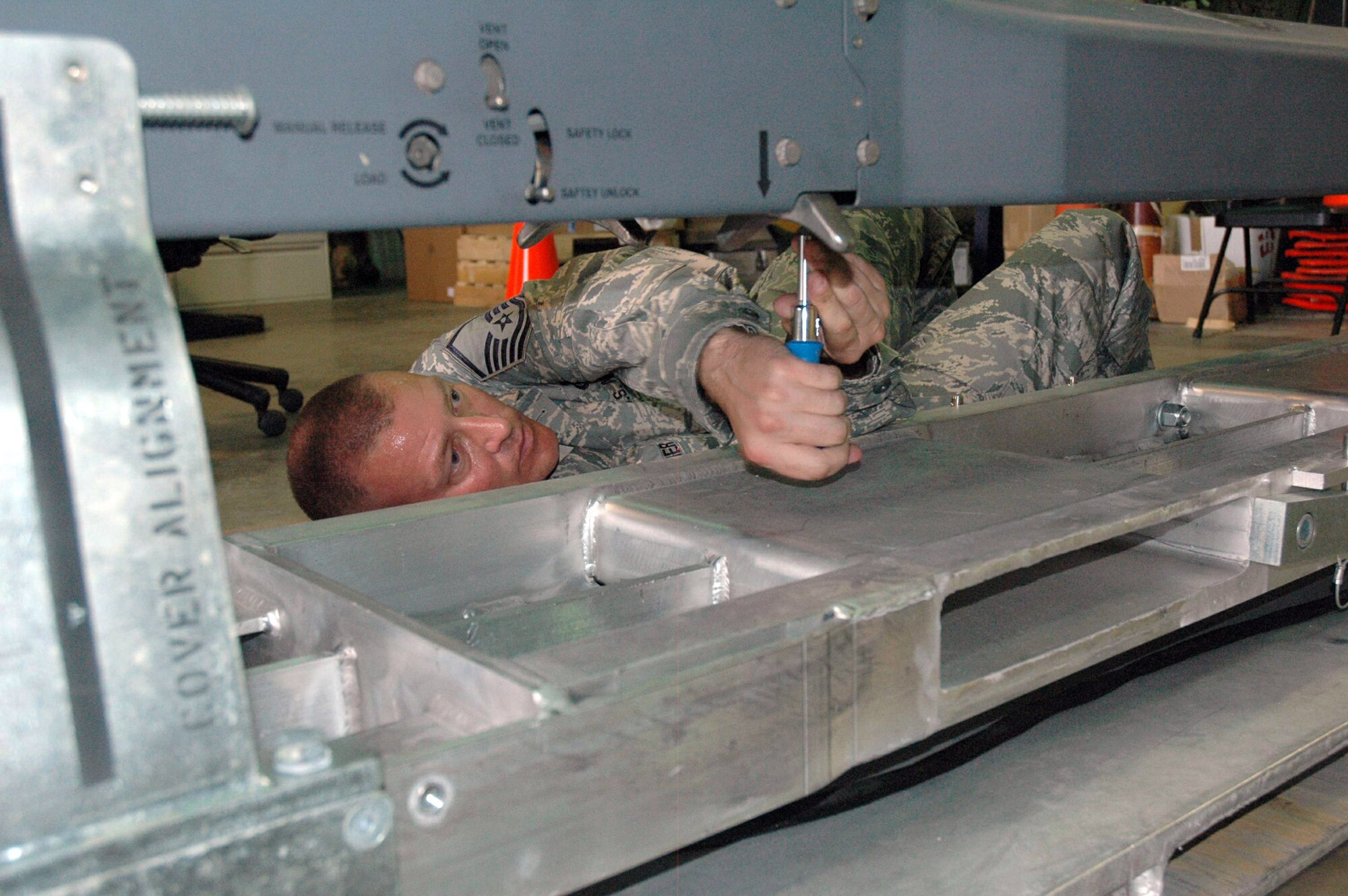 Master Sgt. Brian Mosier tightens the screws to hold a pneumatic carriage system that holds and discharges Small Diameter Bombs June 2 at Eglin Air Force Base, Fla. Sergeant Mosier is assigned to the 681st Armament Systems Squadron Small Diameter Bomb logistics team. (U.S. Air Force photo/Staff Sgt. Stacia Zachary) 
