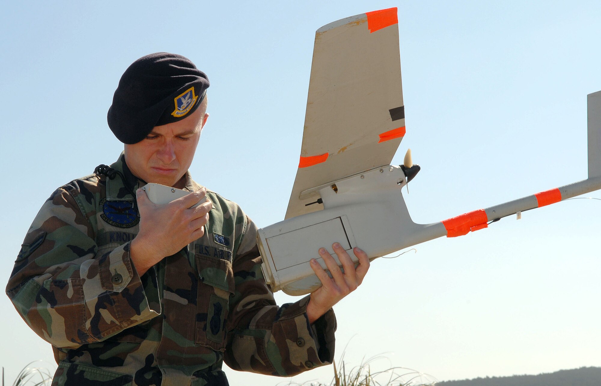 VANDENBERG AIR FORCE BASE, Calif. --  Airman 1st Class Jeff Knoll, 30th Security Forces Squadron, does a pre-flight check of the Raven, Vandenberg's un-manned aerial vehicle.The Raven weighs 4.5 pounds, has a five-foot wingspan and stretches only 38 inches in length. The Raven is equipped with an video camera which streams live feed to an operator on the ground. (U.S. Air Force photo / Senior Airman Erica Stewart)