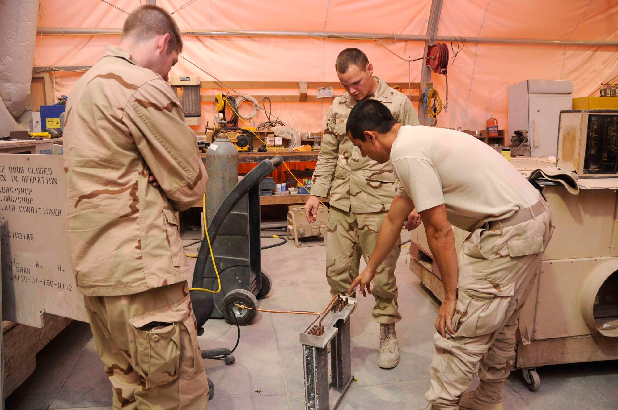 Air Force Academy Cadet Brian Vickers and his mentor, 1st Lt. Benjamin King, visit the heating, ventilation and air conditioning repair shop June 19 at a base in Southwest Asia. The visit will give the cadet insight on tasks Airmen are responsible for in the 379th Civil Engineer Squadron. The cadets are visiting the base as part of the academy's Operation Air Force program, allowing them to experience an active-duty deployment. (U.S. Air Force photo/Senior Airman Domonique Simmons) 