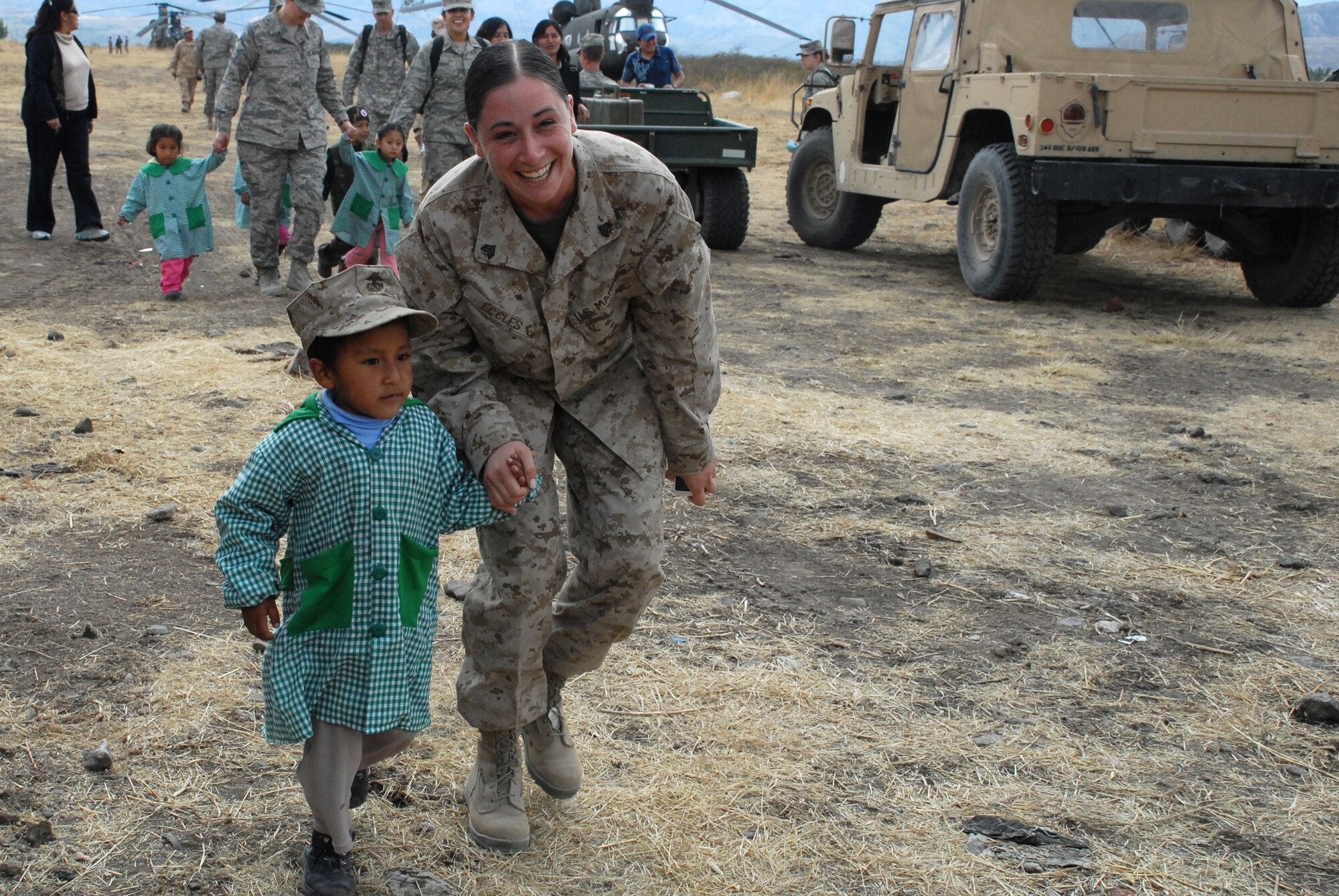 U.S. Marine Sgt. Lindsay Eccles, a legal chief deployed from the Marine Wing Support Squadron 472, Naval Air Station, Joint Reserve Base, Willow Grove, PA, escorts David Huamantinco Arriaran, 4, June 11, during the I.E. Inicial CRL. Miguel Peñarrieta Elementary School’s tour of a U.S. CH-47 Chinook, currently residing in Los Cabitos, Peru. (U.S. Air Force photo/Tech. Sgt. Kerry Jackson)