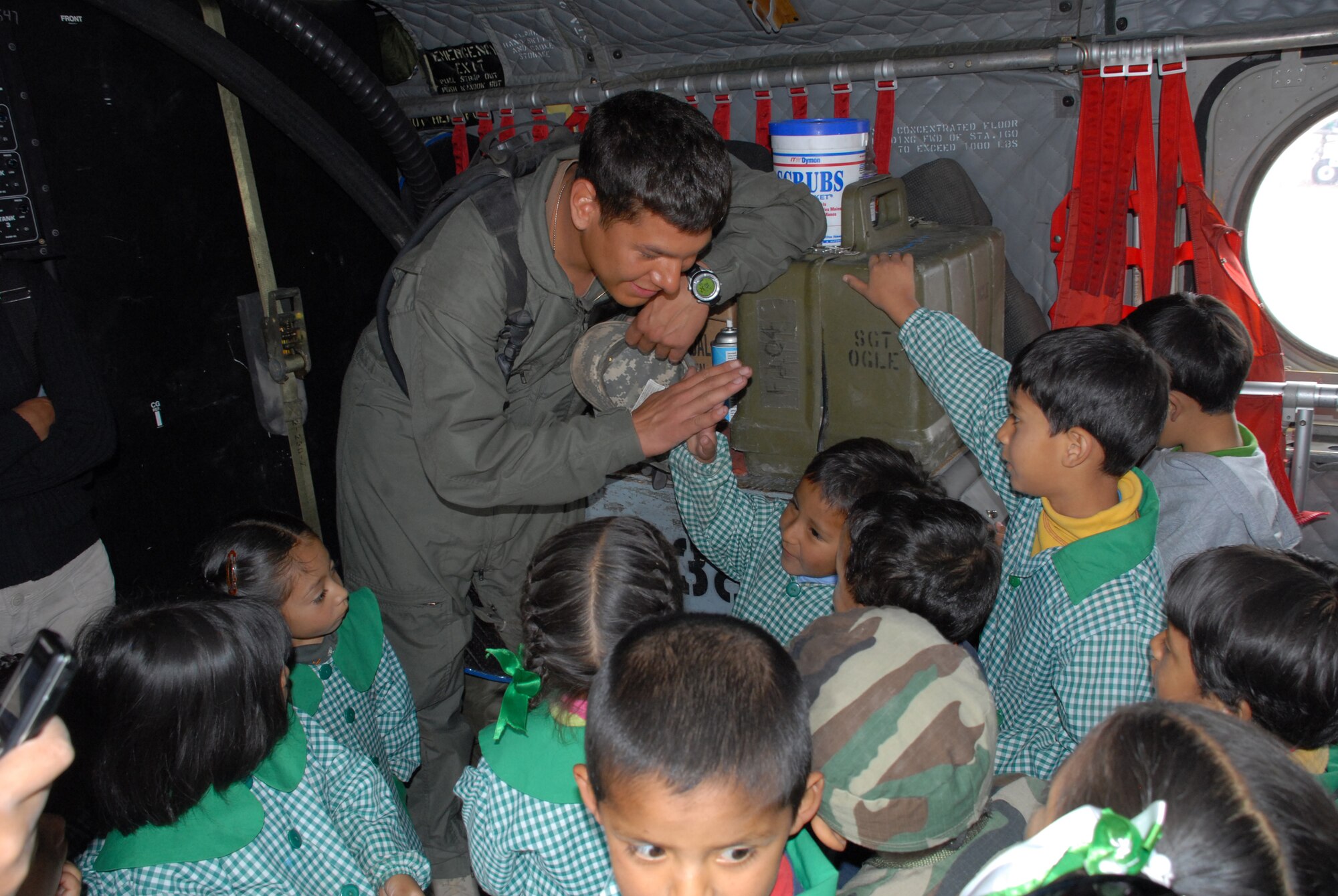 U.S. Army Specialist Josue Moises Coranado-Iglesias, a helicopter engineer assigned to Task Force New Horizons, receives a “high-five” from David Huamantinco Arriaran, 4, June 11, during the I.E. Inicial CRL. Miguel Peñarrieta Elementary School’s tour of a U.S. CH-47 Chinook, currently residing in Los Cabitos, Peru. (U.S. Air Force photo/Airman 1st Class Tracie Forte)