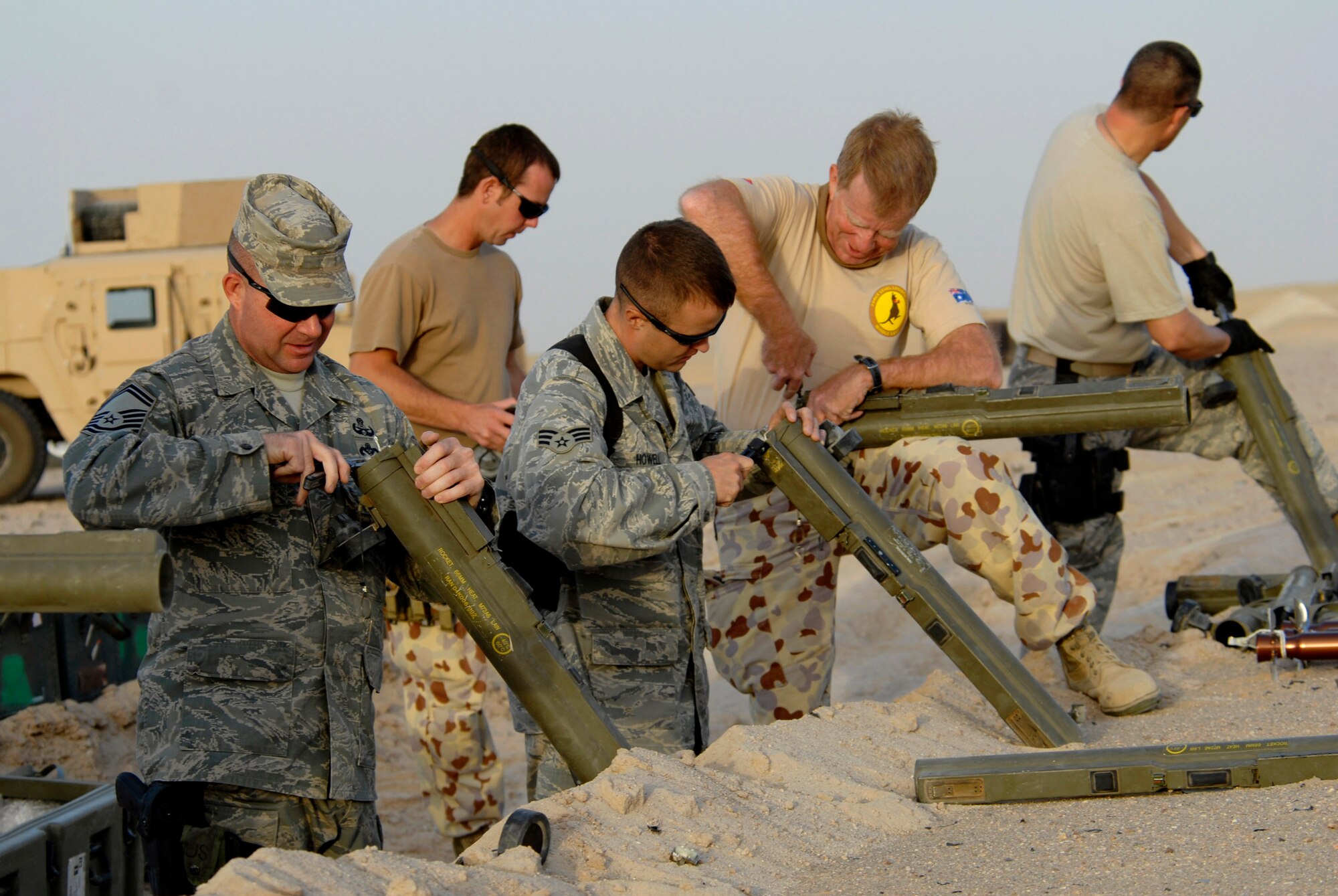 Members from the 386th Expeditionary Civil Engineer Squadron Explosive Ordnance Disposal Flight and Australian army ammunition technicians prepare light anti-armor weapon rockets for disposal in prior to a controlled detonation June 20 at an EOD range in Southwest Asia. The controlled detonation is destroying unserviceable munitions. The joint detonation also provided an opportunity for the U.S. and coalition forces to enhance their relations while learning some of the slight differences in operating procedures. (U.S. Air Force photo/Staff Sgt. Patrick Dixon) 
